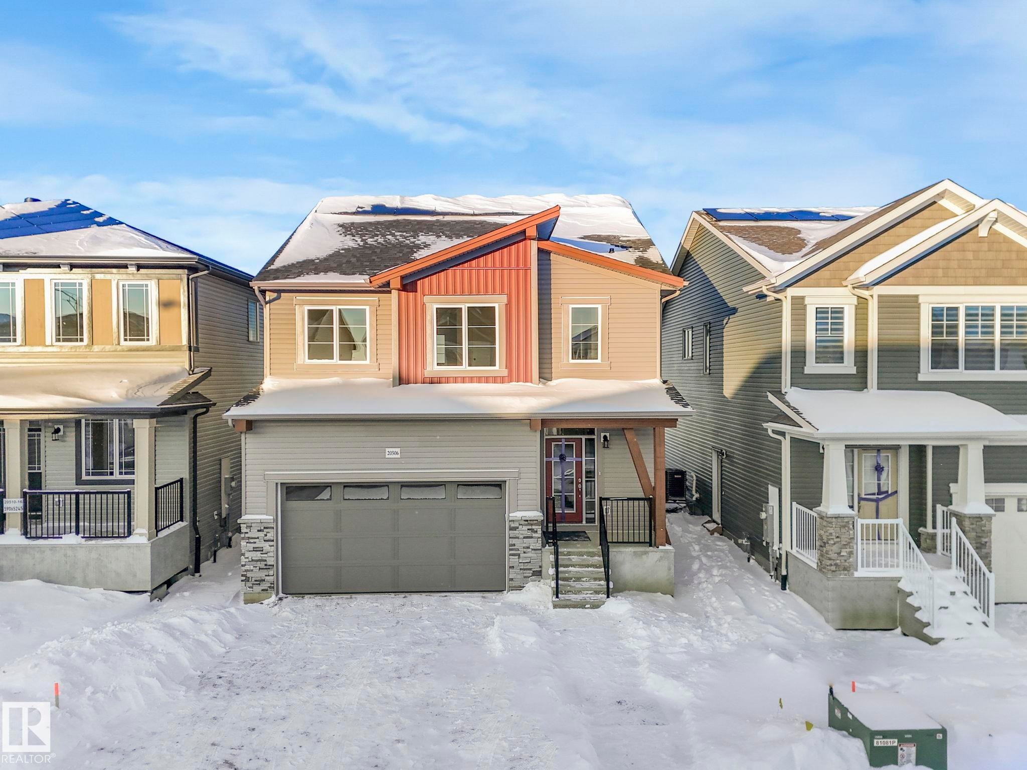 Craftsman house with covered porch, a garage, stone siding, and board and batten siding - 20506 16A Avenue, Edmonton, AB - Outdoor With Facade