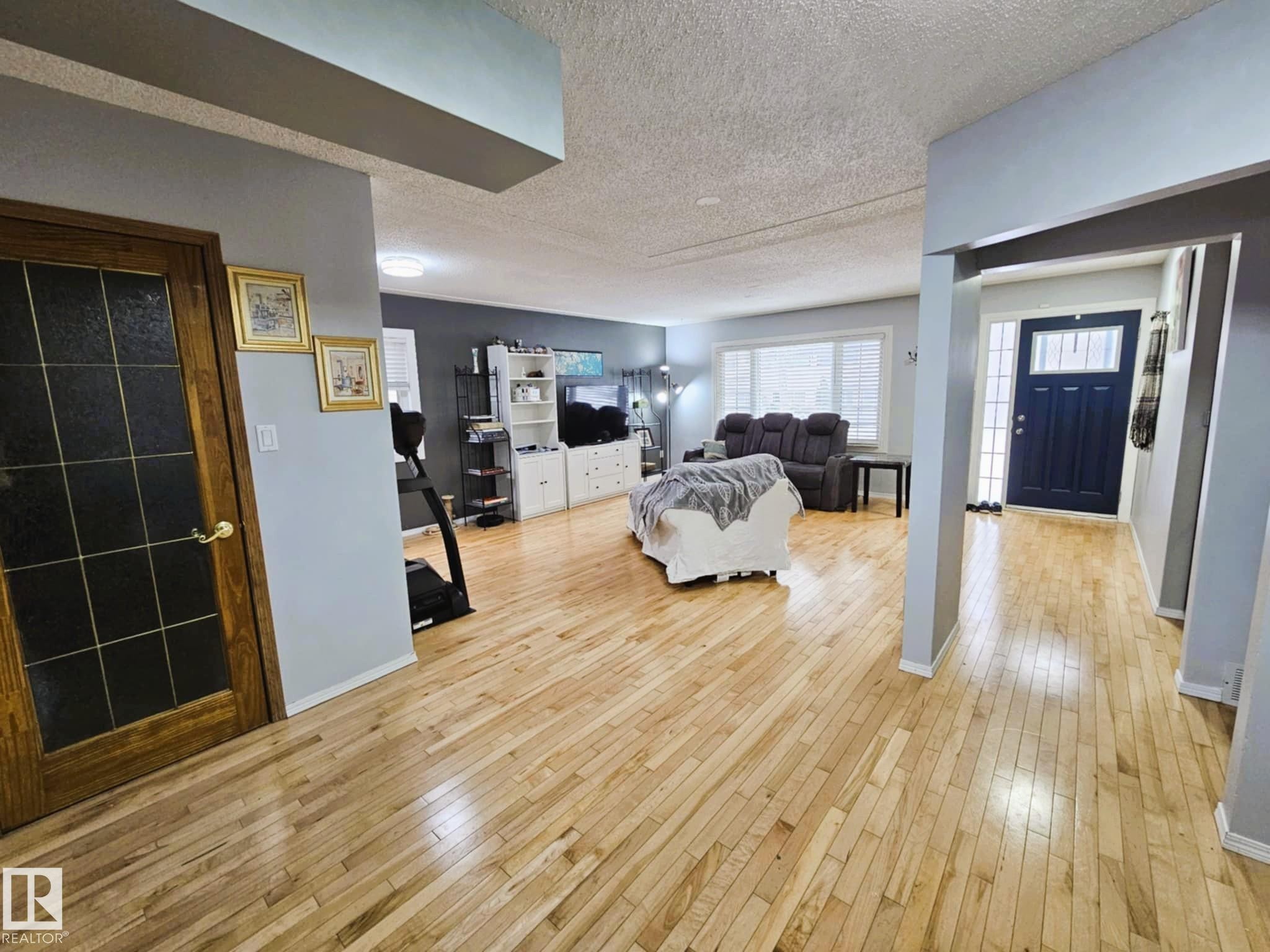 Living area with light wood finished floors and a textured ceiling - 8512 131 Avenue, Edmonton, AB - Indoor