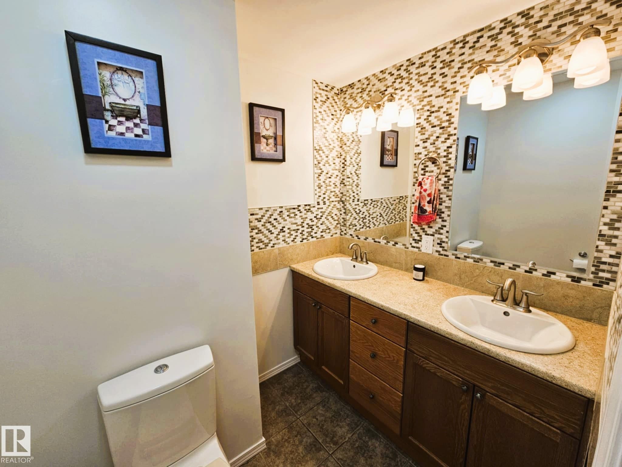 Full bathroom featuring tasteful backsplash, double vanity, and dark tile patterned floors - 8512 131 Avenue, Edmonton, AB - Indoor Photo Showing Bathroom