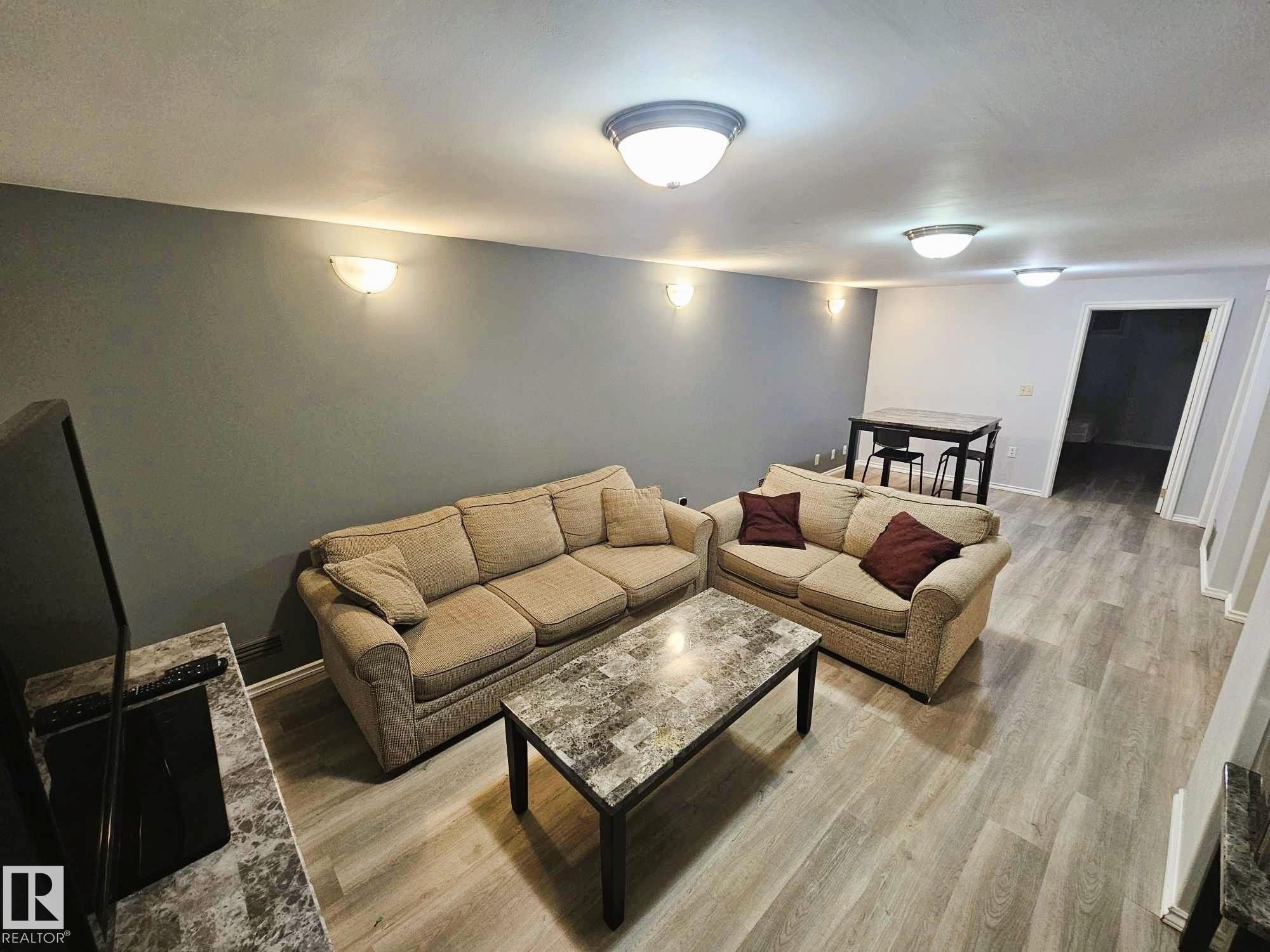 Living area featuring light wood-type flooring and baseboards - 8512 131 Avenue, Edmonton, AB - Indoor Photo Showing Living Room