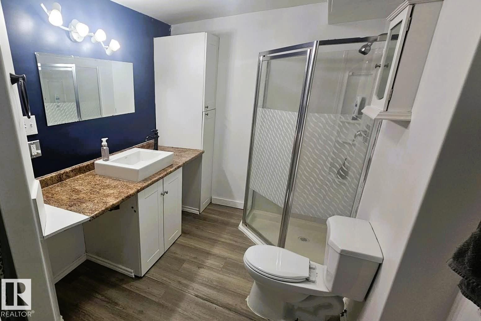 Bathroom with vanity, a shower stall, and dark wood-type flooring - 8512 131 Avenue, Edmonton, AB - Indoor Photo Showing Bathroom