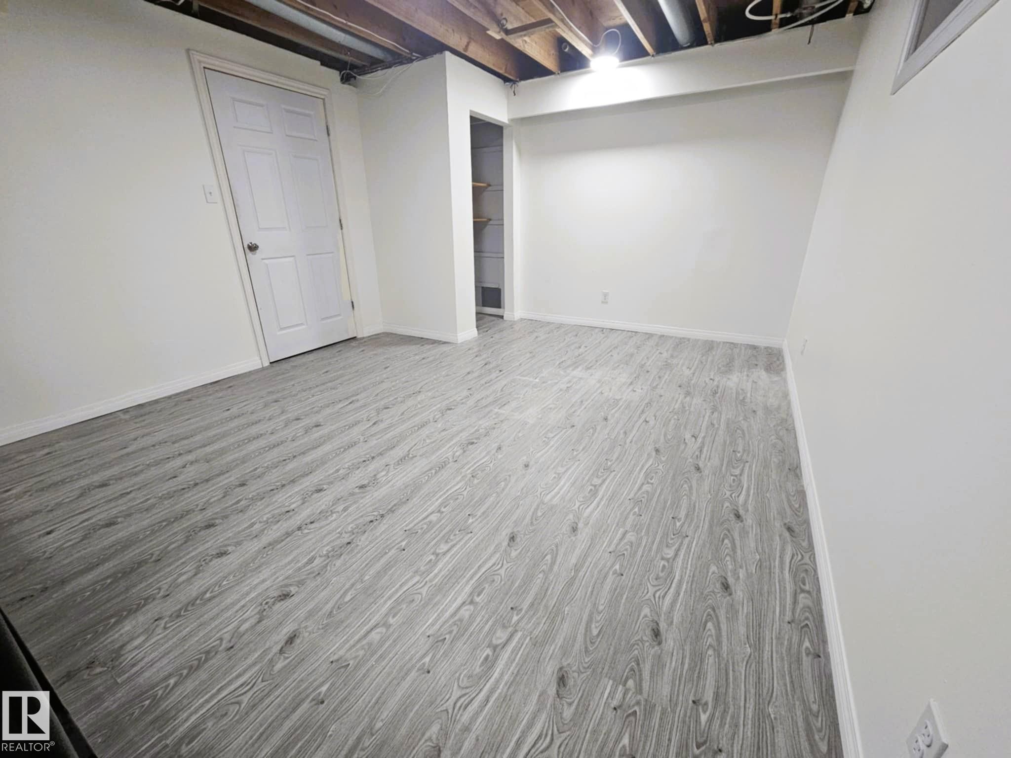 Finished below grade area featuring light wood-type flooring and baseboards - 8512 131 Avenue, Edmonton, AB - Indoor Photo Showing Basement