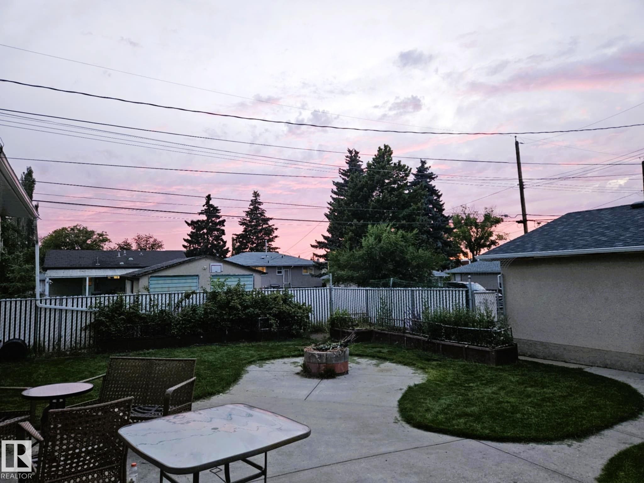 Patio terrace at dusk with a patio, a fire pit, and a fenced backyard - 8512 131 Avenue, Edmonton, AB - Outdoor