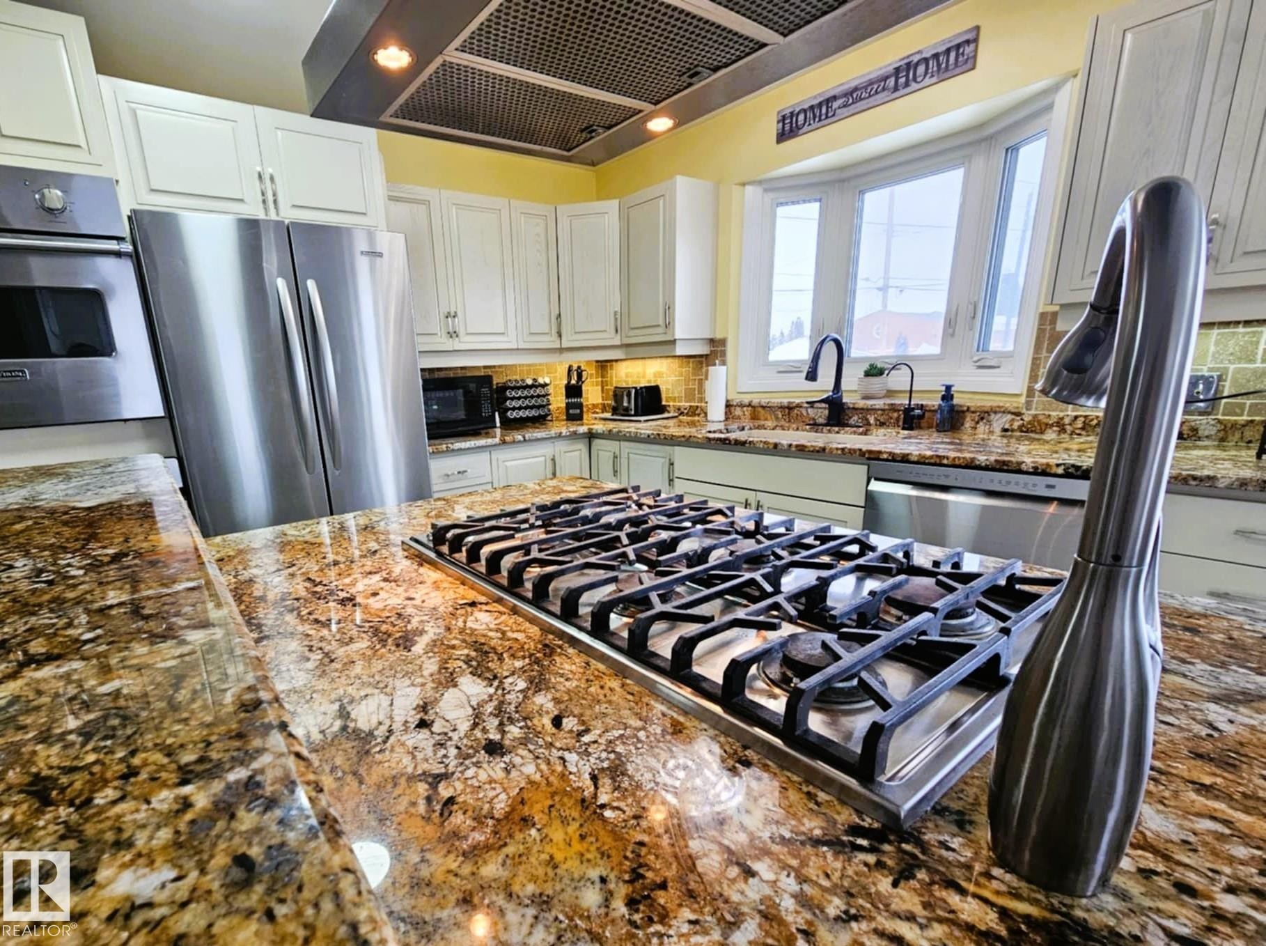 Kitchen featuring extractor fan, dark stone counters, stainless steel appliances, white cabinets, and tasteful backsplash - 8512 131 Avenue, Edmonton, AB - Indoor Photo Showing Kitchen With Upgraded Kitchen