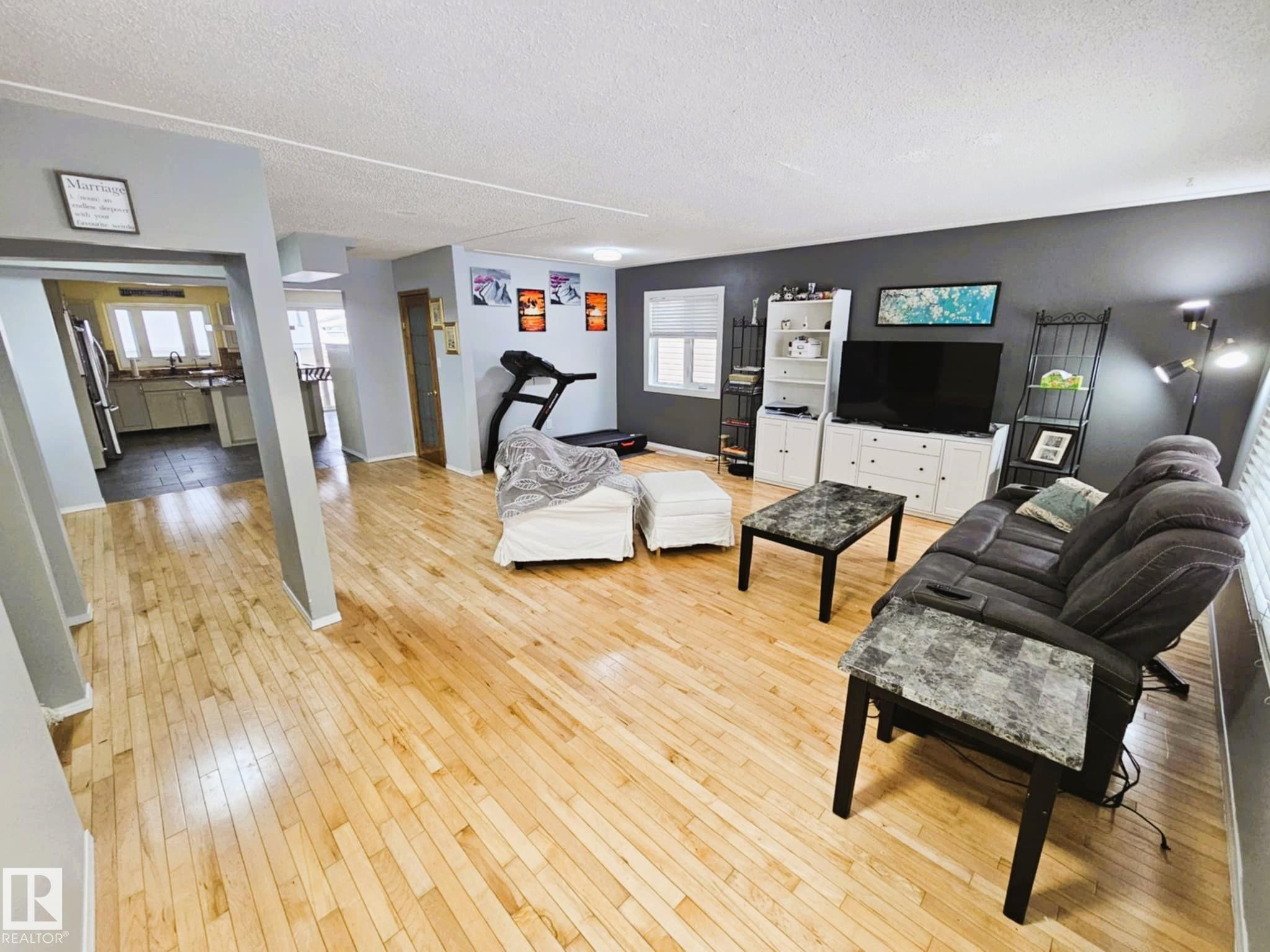Living area with light wood-style flooring and a textured ceiling - 8512 131 Avenue, Edmonton, AB - Indoor