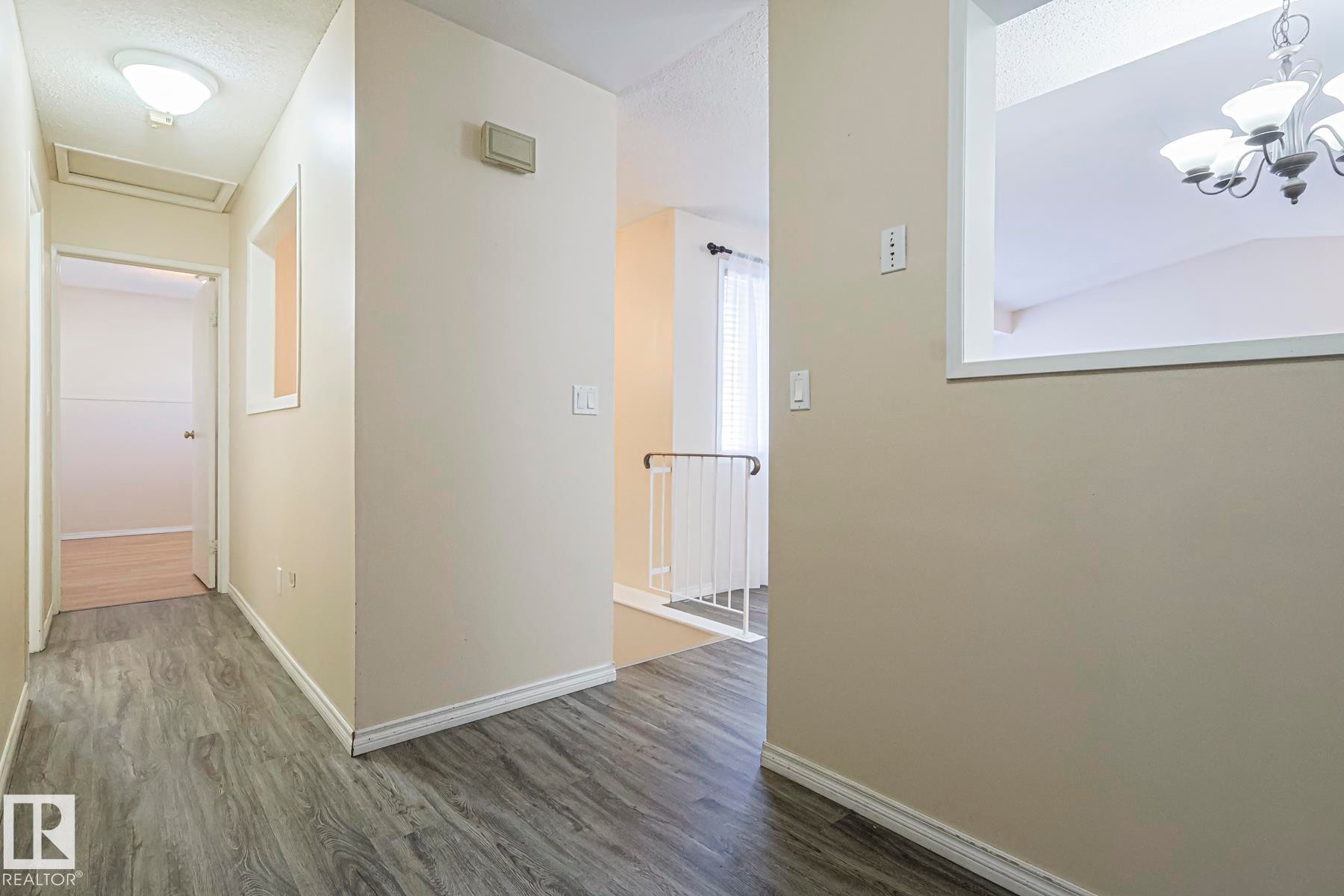 Hallway featuring dark wood finished floors and a chandelier - 1526 69 Street Nw, Edmonton, AB - Indoor Photo Showing Other Room