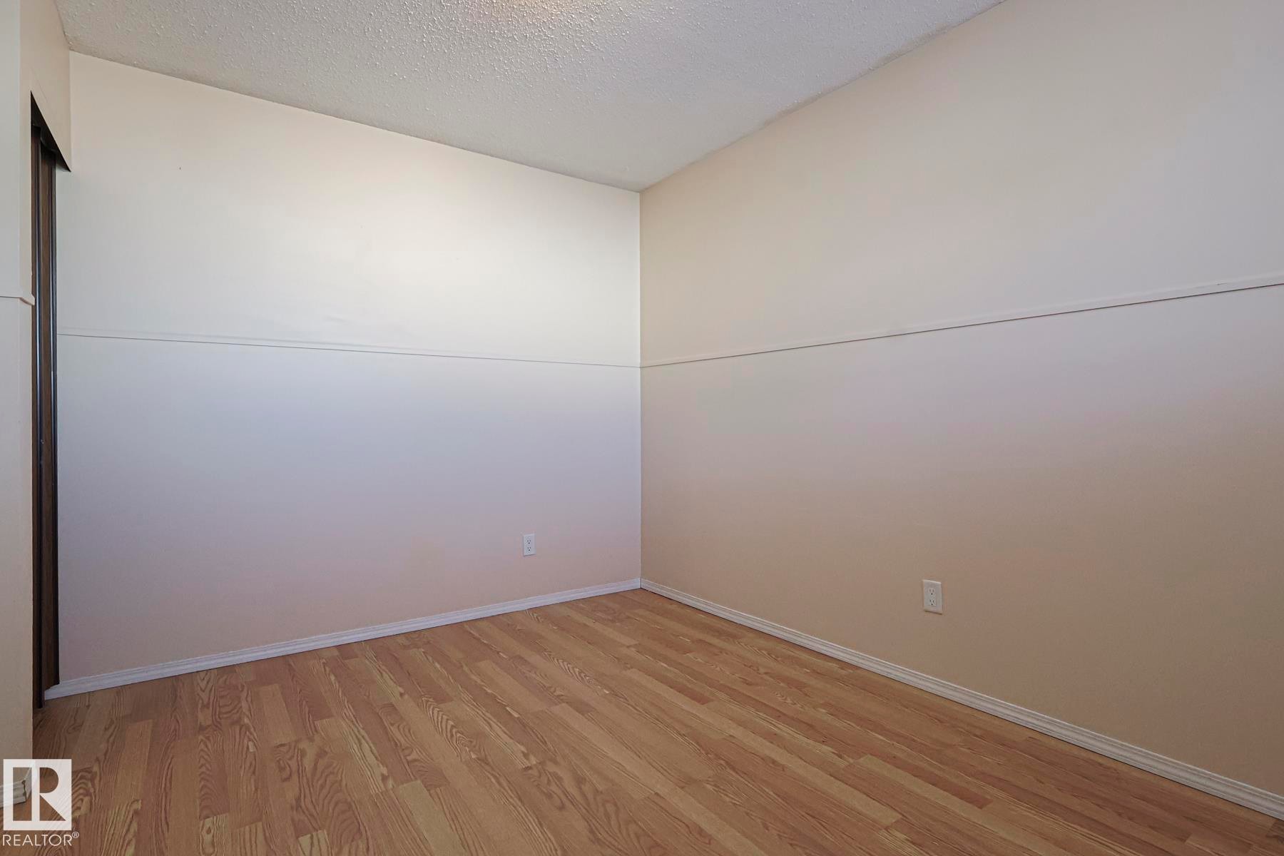 Unfurnished room with a textured ceiling and light wood finished floors - 1526 69 Street Nw, Edmonton, AB - Indoor Photo Showing Other Room