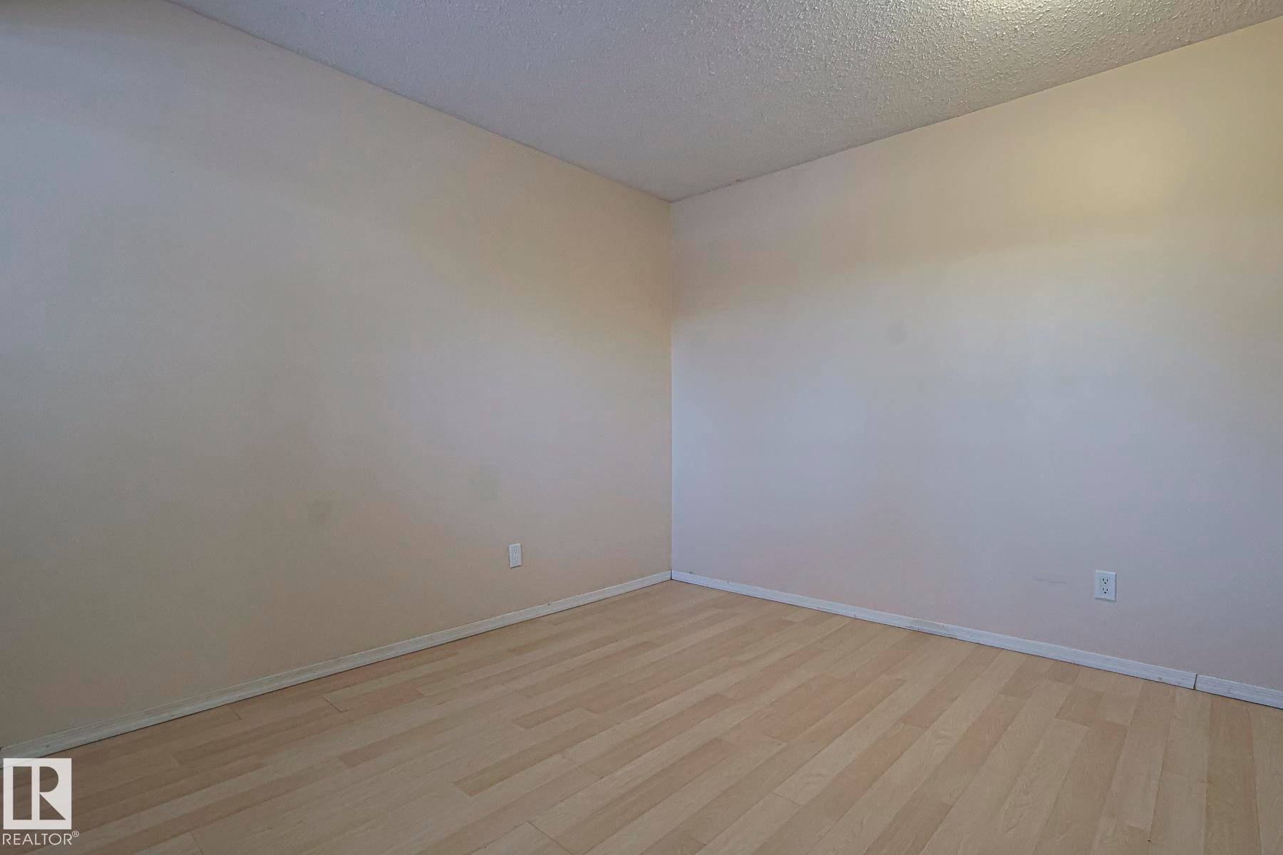 Unfurnished room featuring light wood-style flooring and a textured ceiling - 1526 69 Street Nw, Edmonton, AB - Indoor Photo Showing Other Room