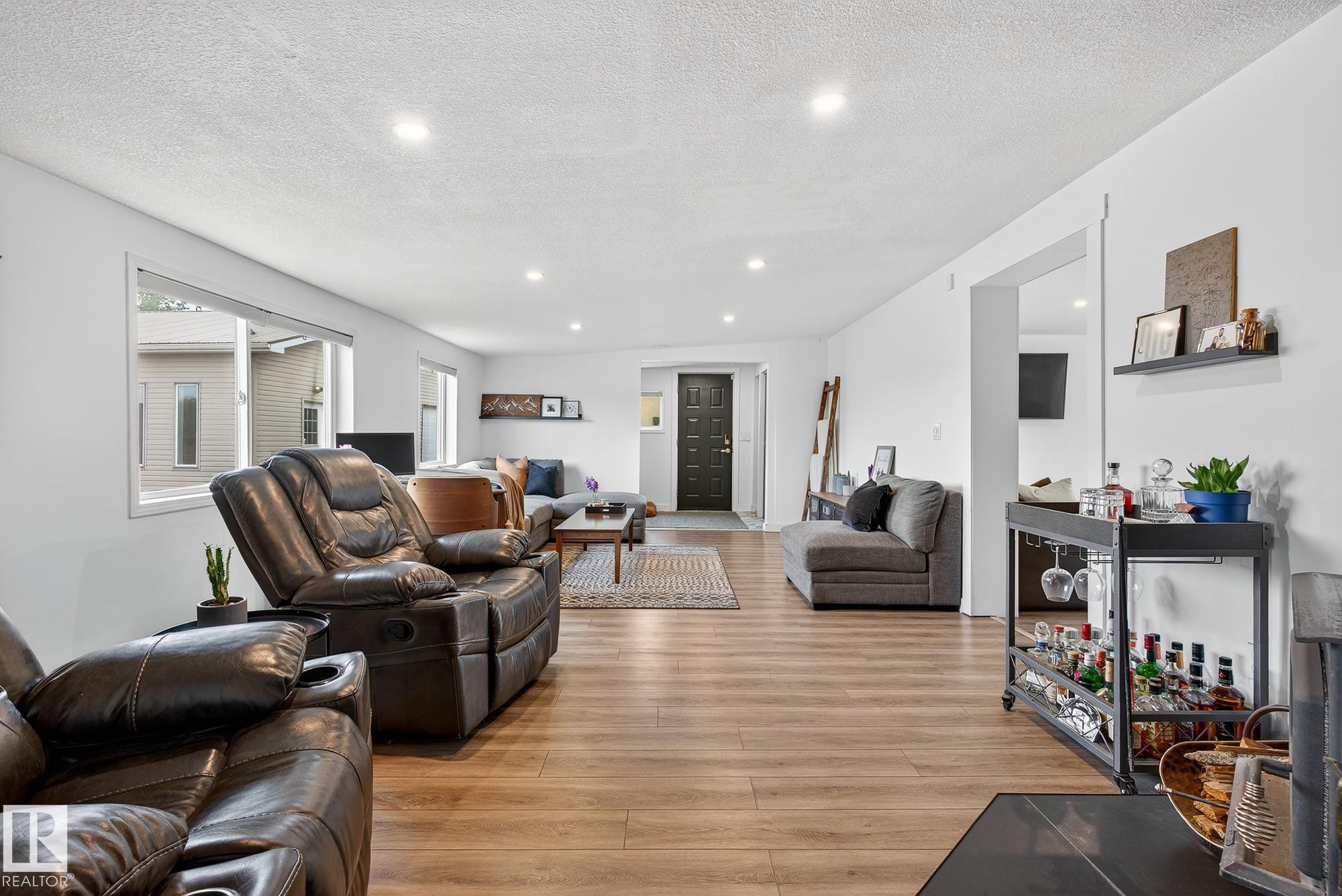 Living area with light wood finished floors, a textured ceiling, and recessed lighting - 23509A Twp Road 484, Rural Leduc County, AB - Indoor Photo Showing Living Room
