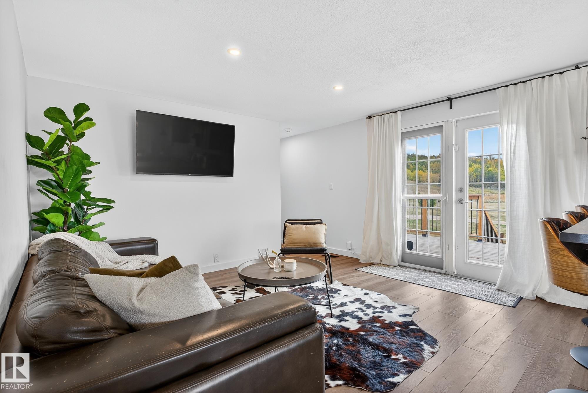 Living area featuring wood finished floors, french doors, recessed lighting, and a textured ceiling - 23509A Twp Road 484, Rural Leduc County, AB - Indoor Photo Showing Living Room
