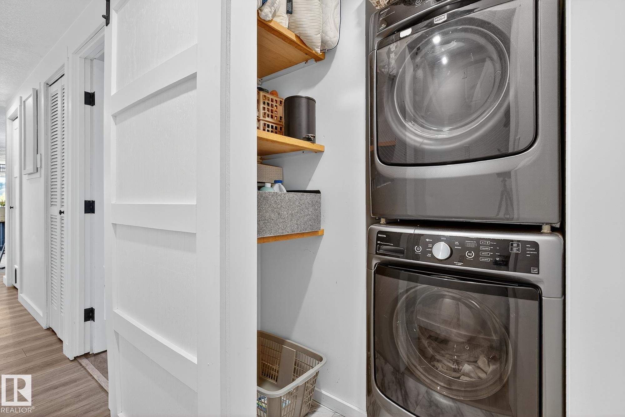 Laundry area featuring stacked washer / dryer and light wood-type flooring - 23509A Twp Road 484, Rural Leduc County, AB - Indoor Photo Showing Laundry Room
