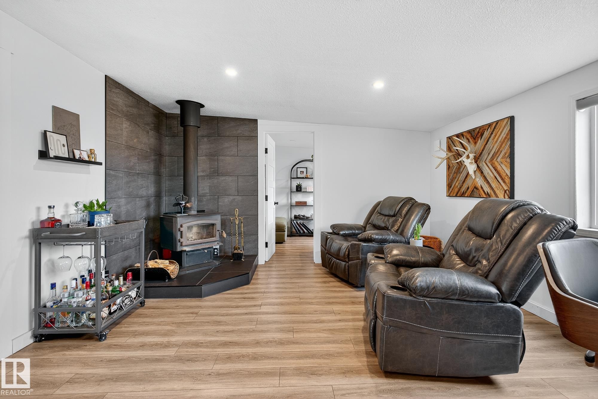 Living area with light wood-style floors, a wood stove, and recessed lighting - 23509A Twp Road 484, Rural Leduc County, AB - Indoor