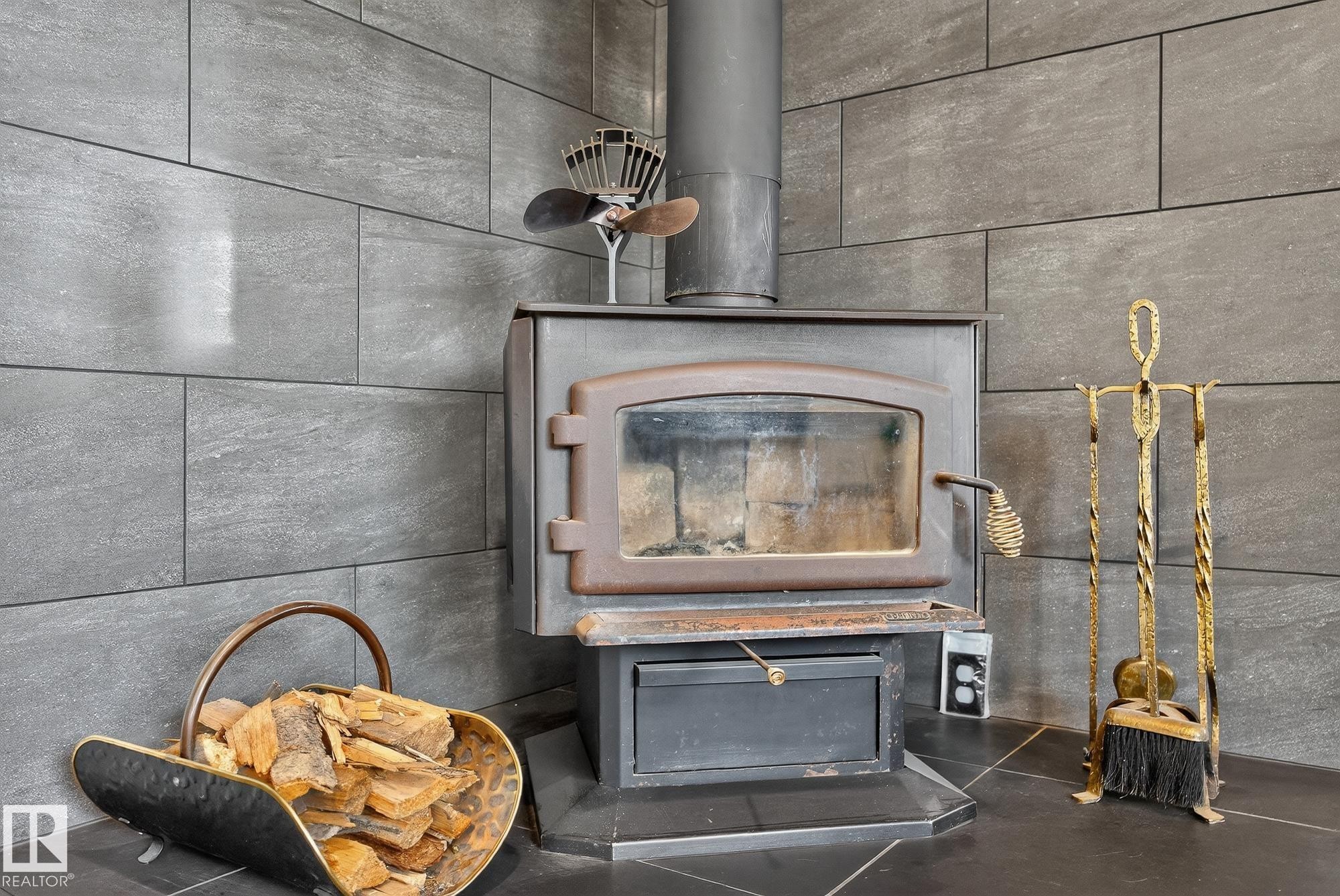 Detailed view of a wood stove - 23509A Twp Road 484, Rural Leduc County, AB - Indoor Photo Showing Other Room With Fireplace