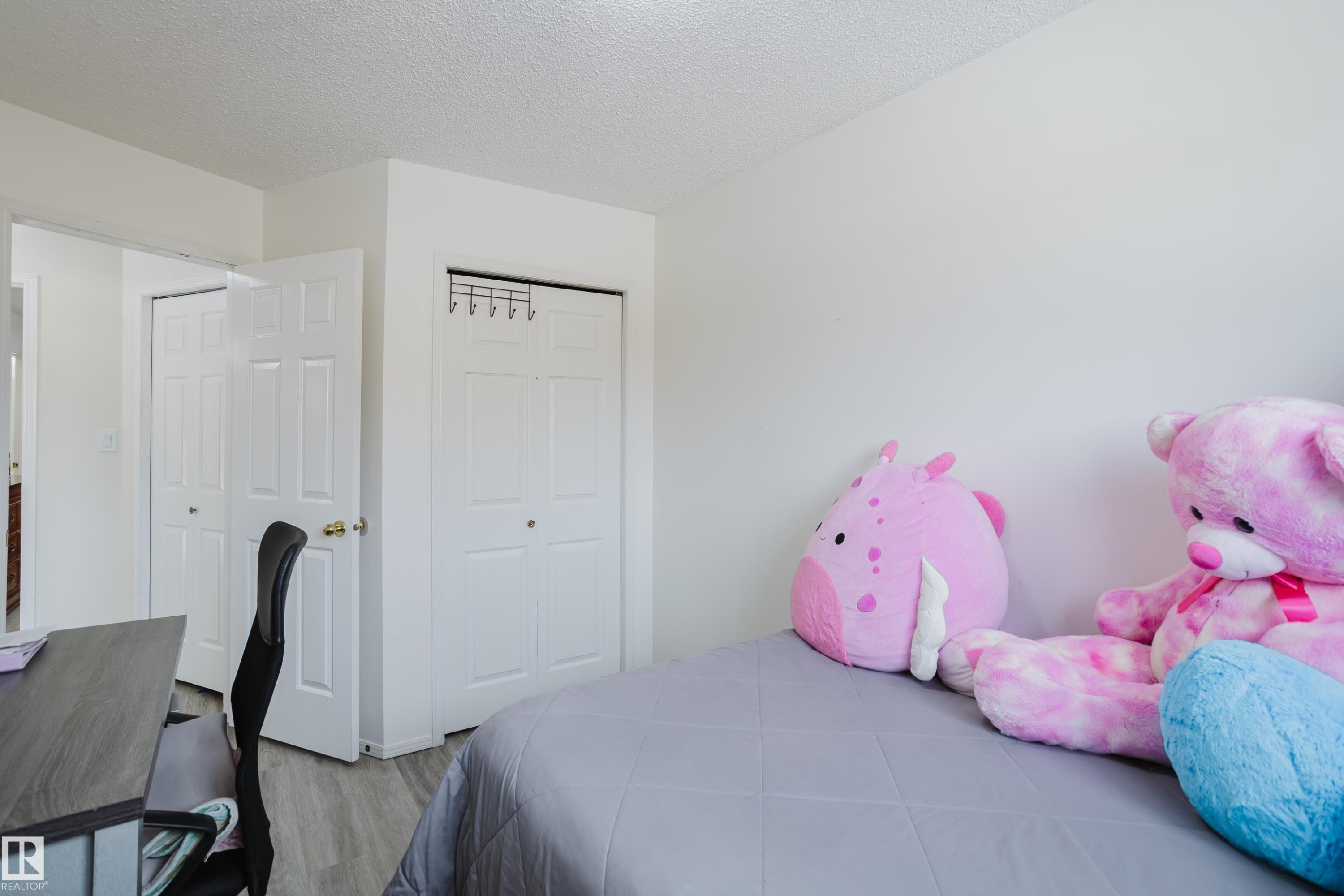 Bedroom with a textured ceiling, a closet, wood finished floors, and an office area - 236 Lago Lindo Crescent, Edmonton, AB - Indoor Photo Showing Bedroom