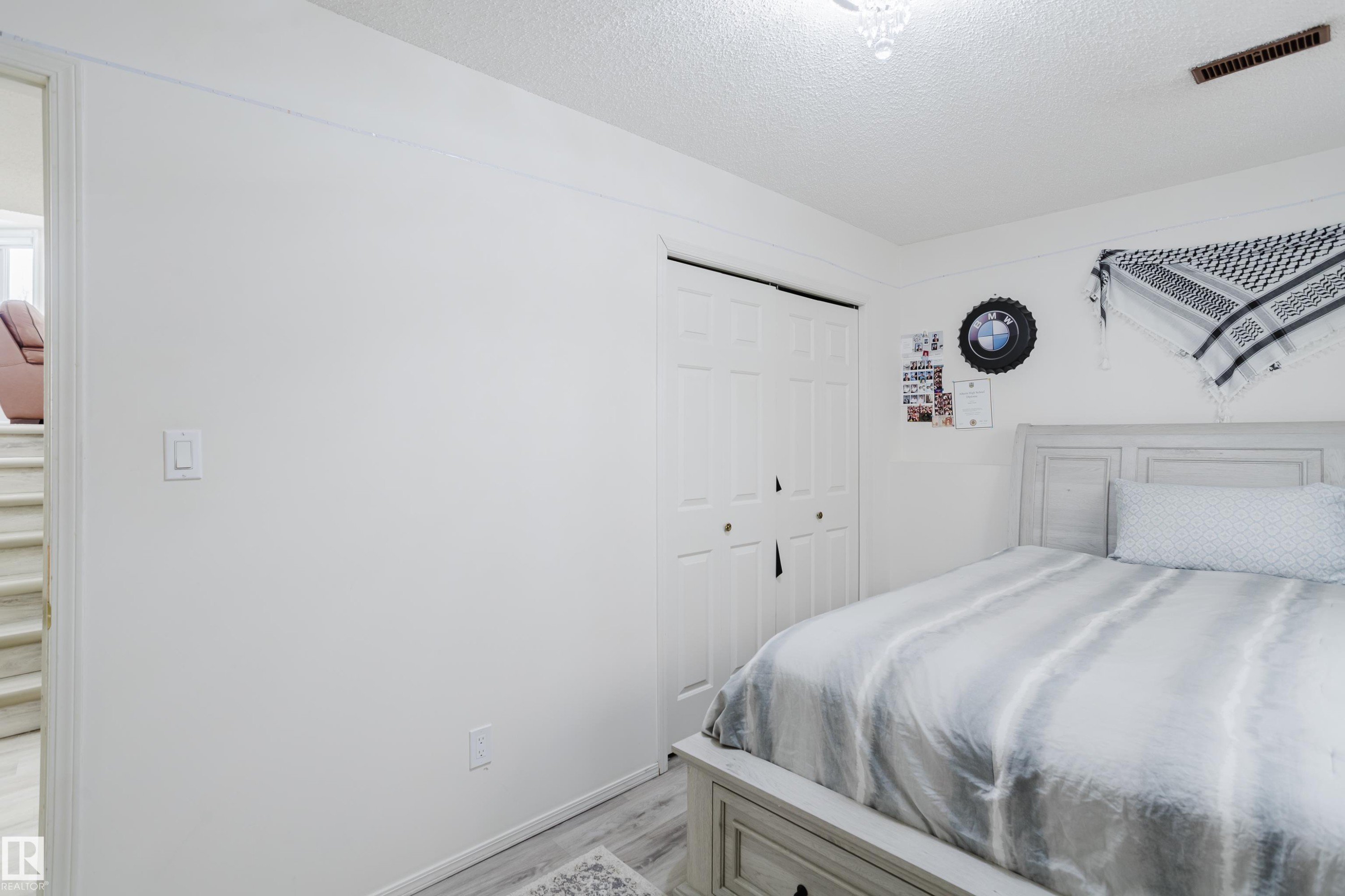 Bedroom with a textured ceiling, light wood-style flooring, and a closet - 236 Lago Lindo Crescent, Edmonton, AB - Indoor Photo Showing Bedroom