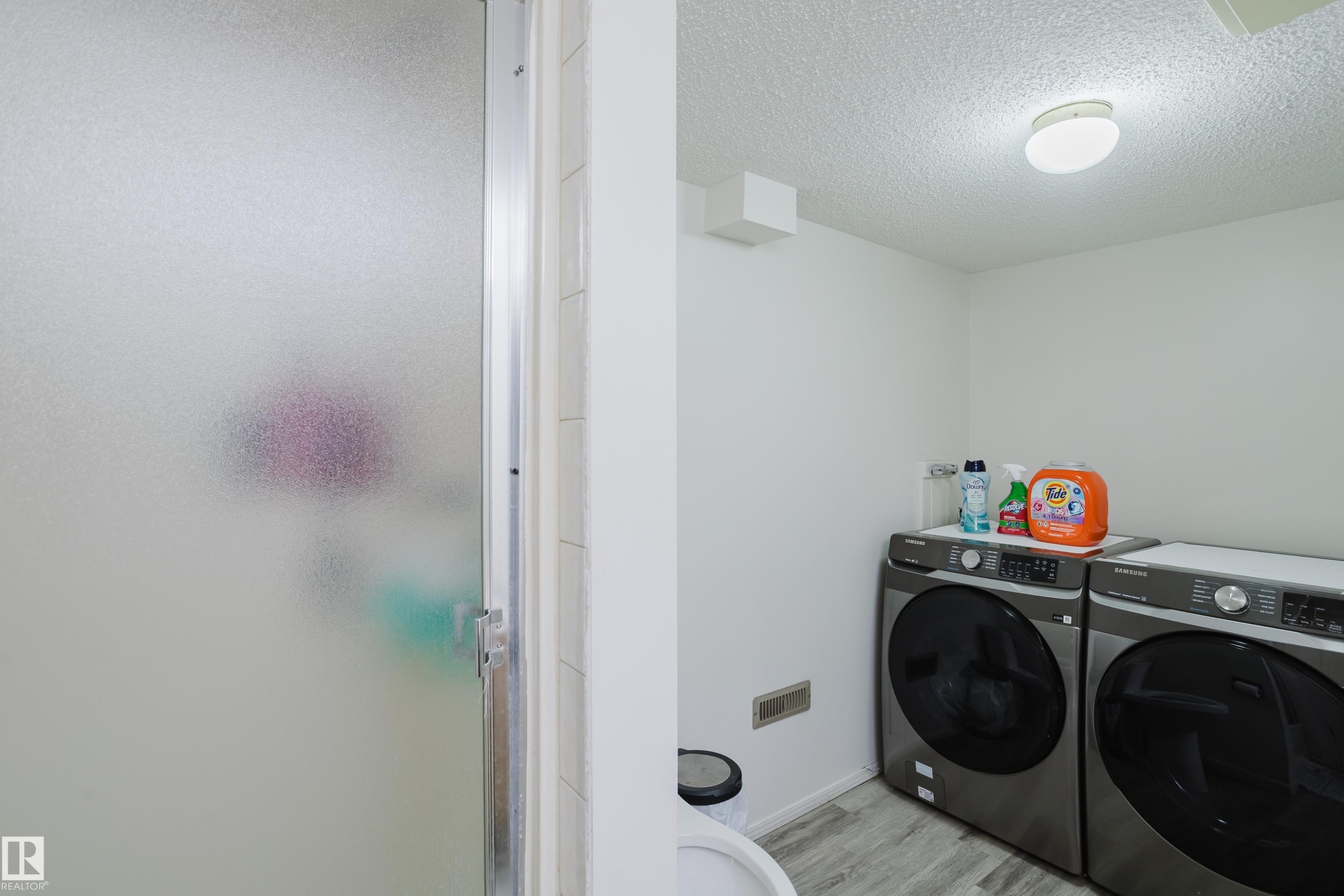 Laundry area featuring a textured ceiling, washing machine and clothes dryer, and light wood-style floors - 236 Lago Lindo Crescent, Edmonton, AB - Indoor Photo Showing Laundry Room