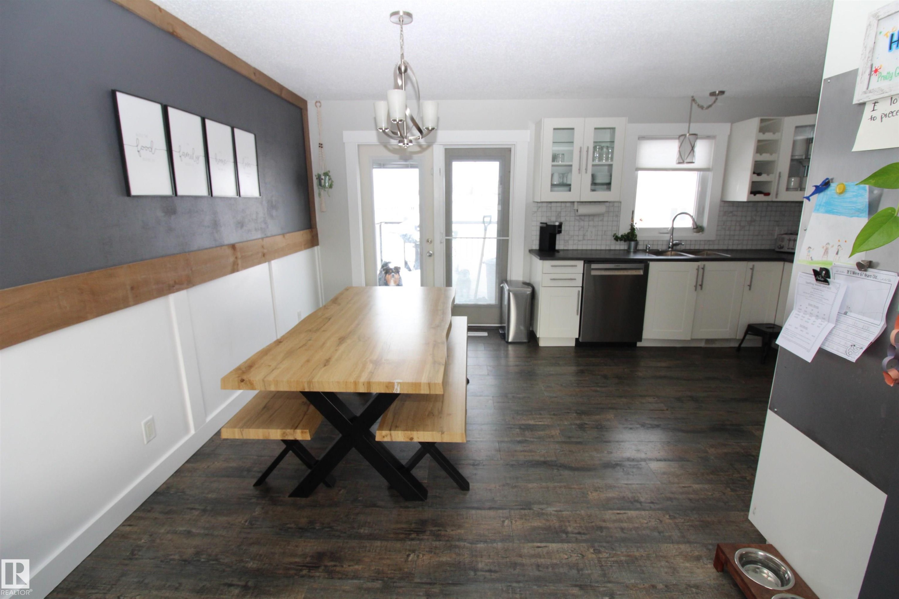 Dining area with dark wood-style floors and a chandelier - 10319 106 Ave, Westlock, AB - Indoor