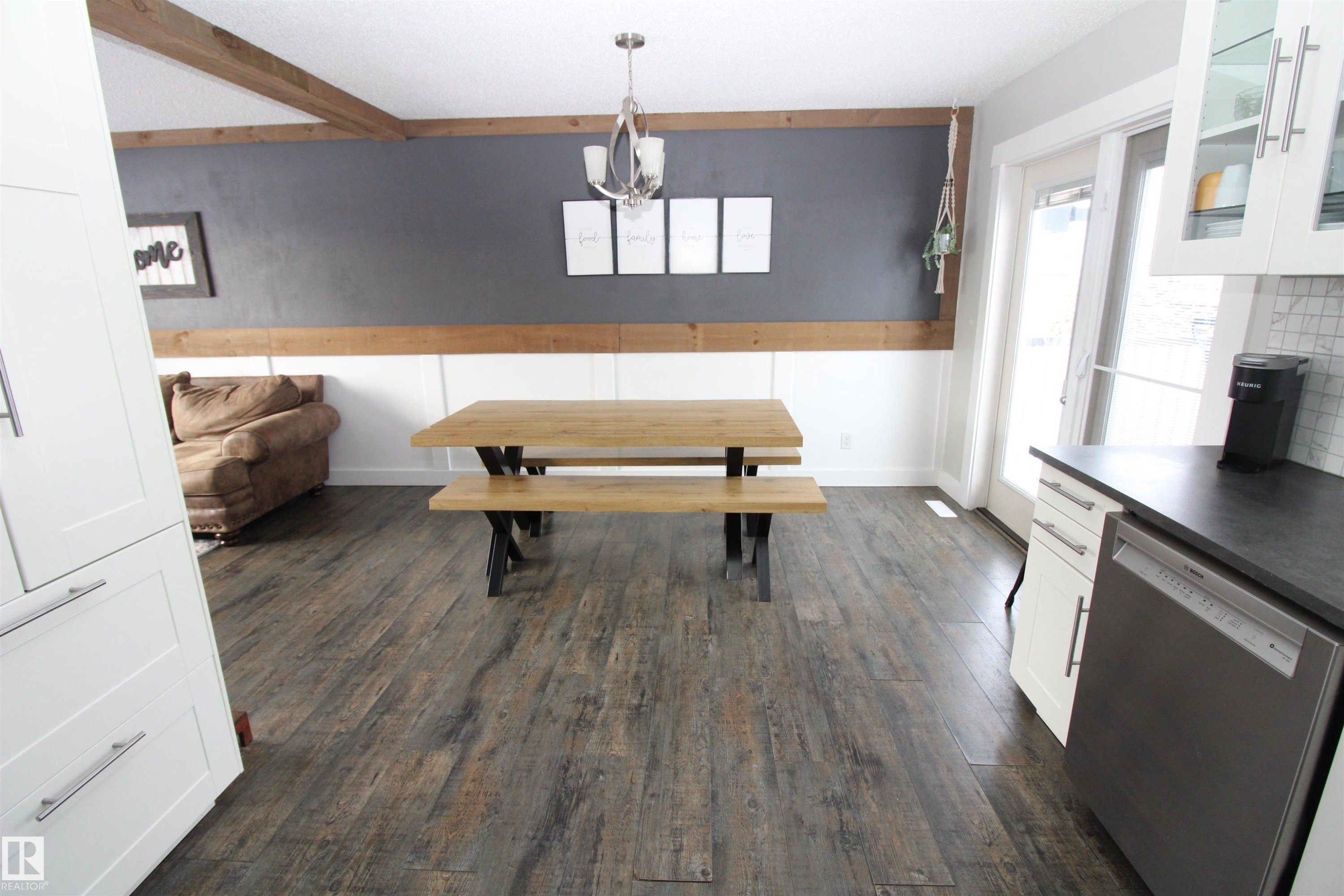 Dining space with healthy amount of natural light, dark wood finished floors, beamed ceiling, and suspended lighting - 10319 106 Ave, Westlock, AB - Indoor Photo Showing Kitchen With Fireplace