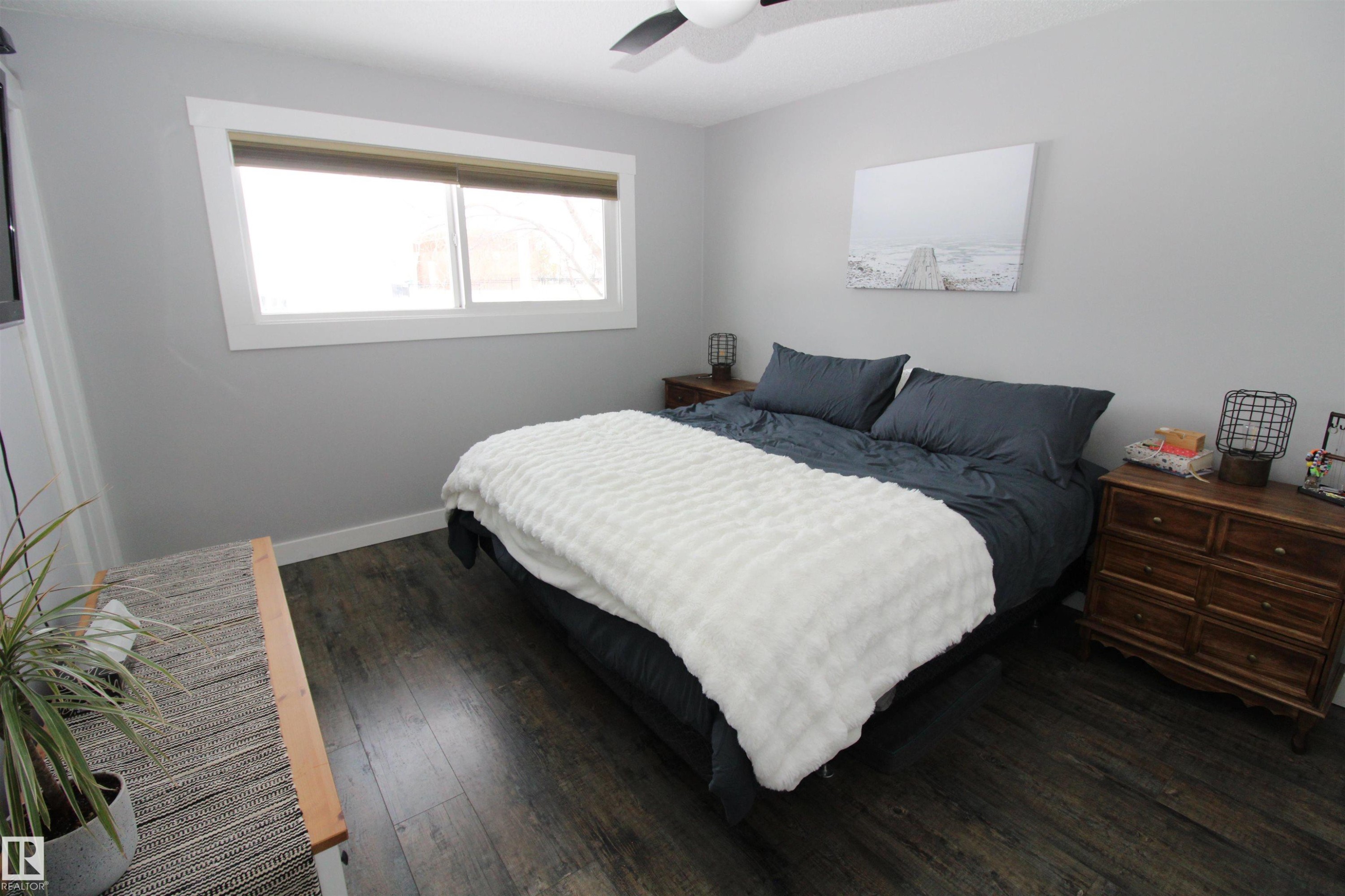 Bedroom featuring dark wood-style floors and a ceiling fan - 10319 106 Ave, Westlock, AB - Indoor Photo Showing Bedroom