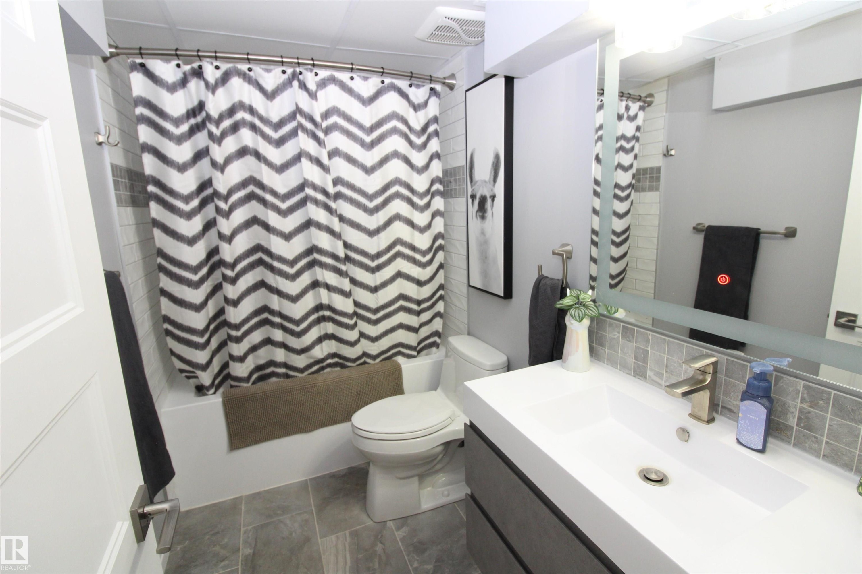Bathroom with vanity, shower / tub combo with curtain, and decorative backsplash - 10319 106 Ave, Westlock, AB - Indoor Photo Showing Bathroom