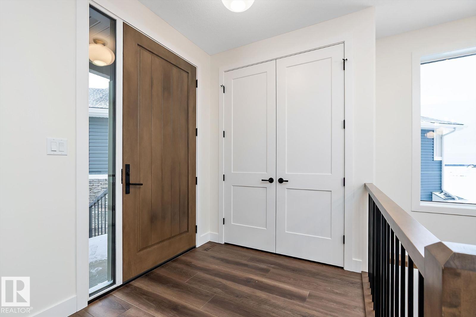 Entrance foyer with healthy amount of natural light and dark wood-style flooring - 128 Lilac Close, Leduc, AB - Indoor Photo Showing Other Room