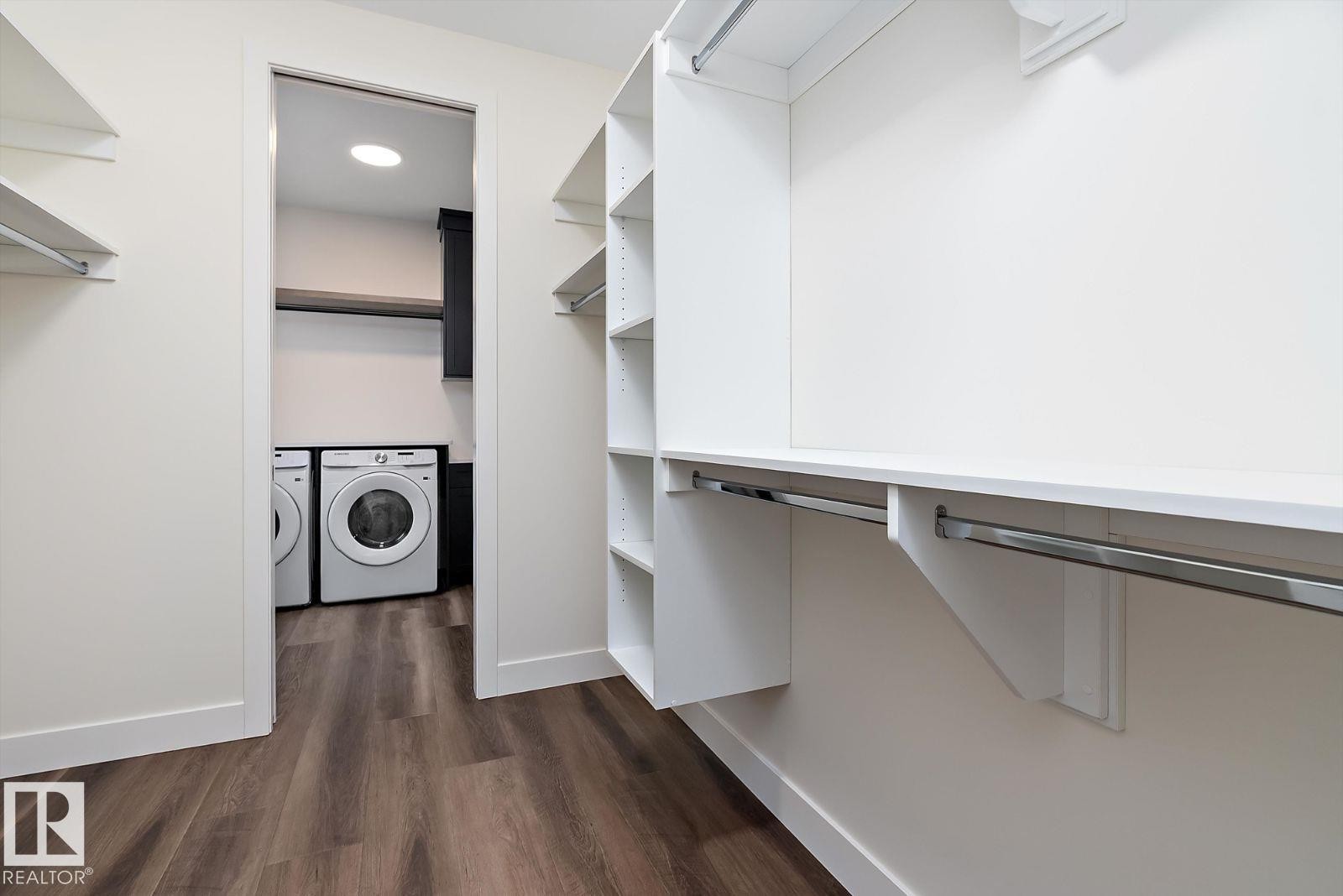 Walk in closet featuring dark wood-style flooring and washing machine and dryer - 128 Lilac Close, Leduc, AB - Indoor