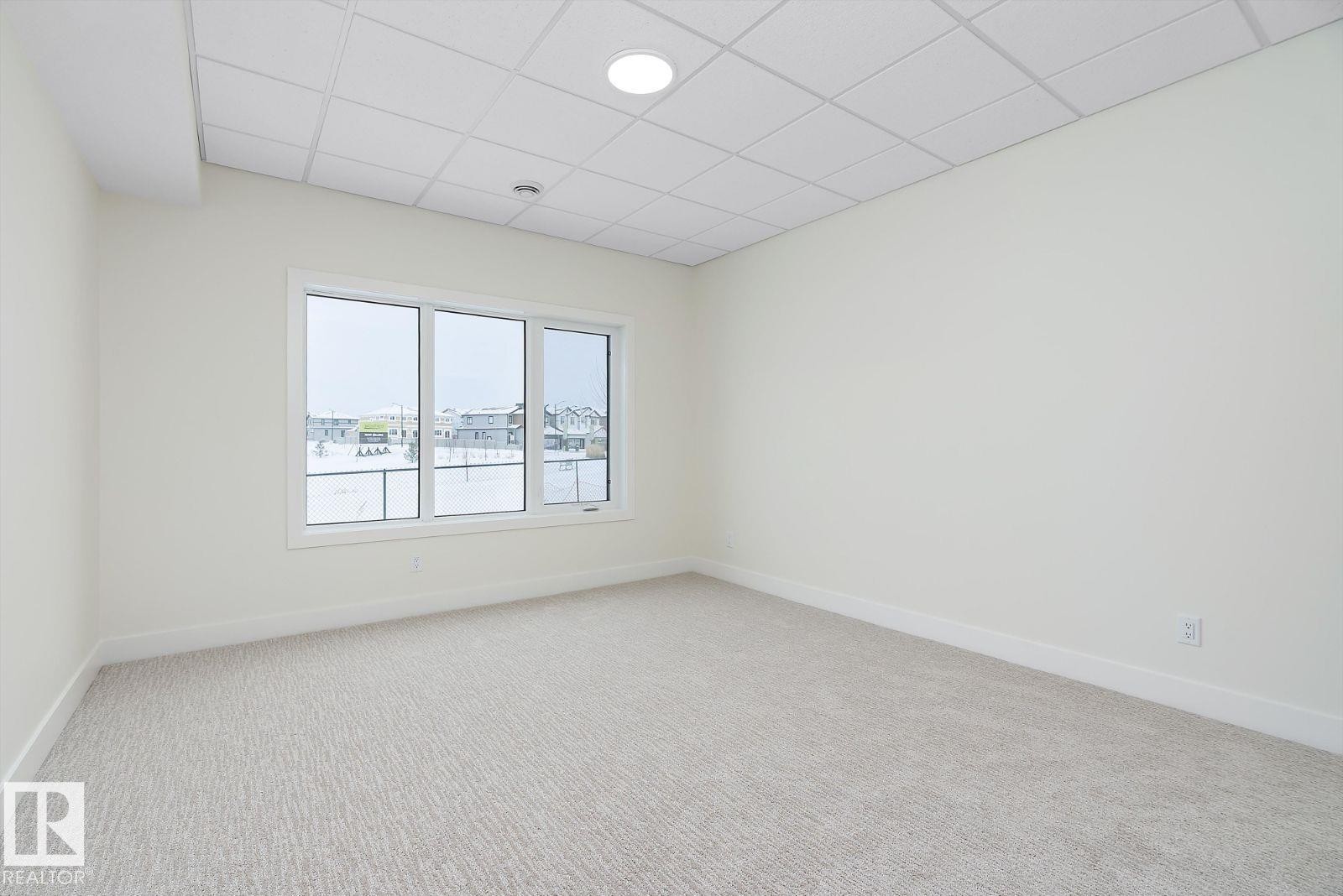 Spare room featuring a paneled ceiling and light colored carpet - 128 Lilac Close, Leduc, AB - Indoor Photo Showing Other Room