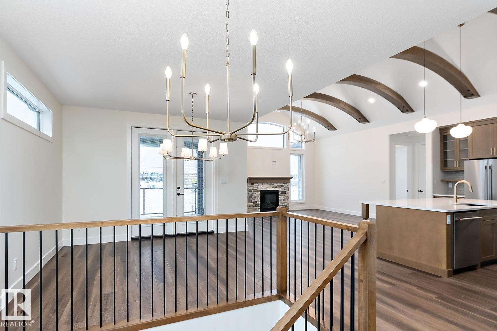 Hallway featuring a barrel ceiling, dark wood-type flooring, a chandelier, and an upstairs landing - 128 Lilac Close, Leduc, AB - Indoor