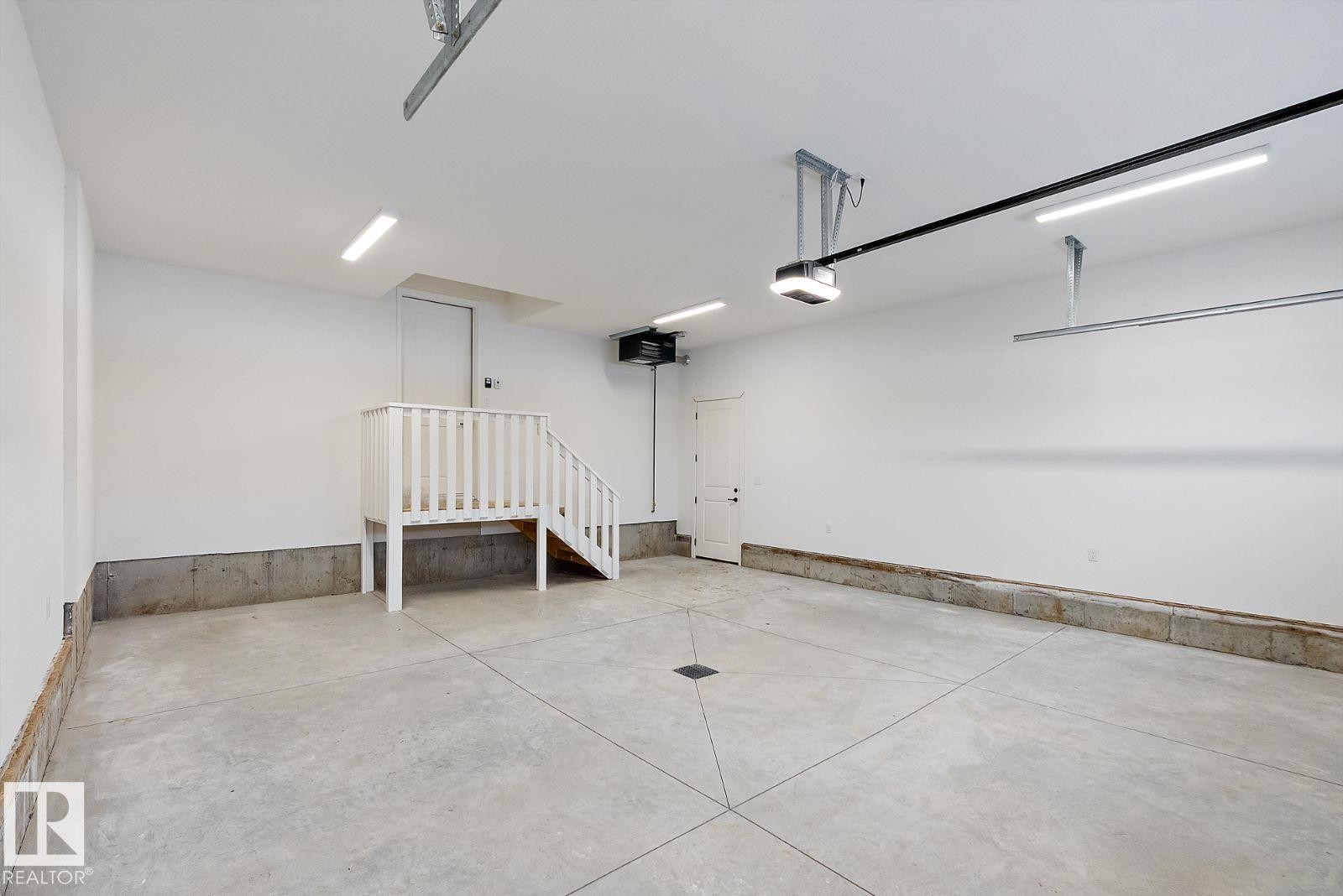 Garage featuring a heating unit and a garage door opener - 128 Lilac Close, Leduc, AB - Indoor Photo Showing Garage