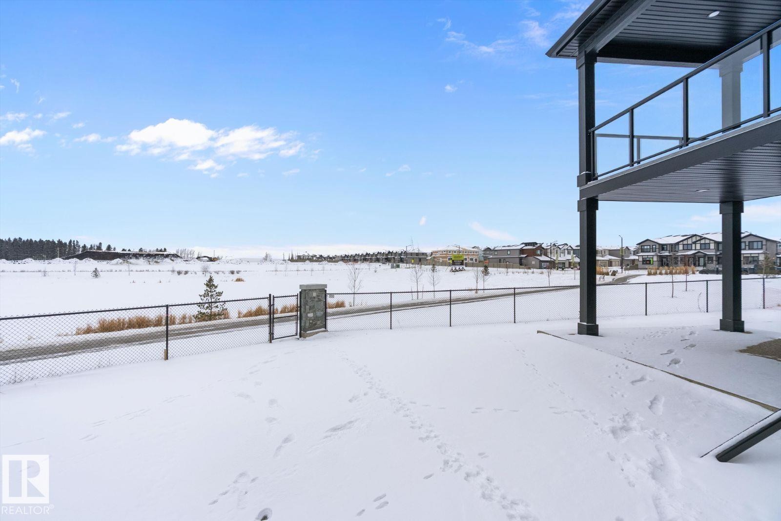 Yard layered in snow with a residential view - 128 Lilac Close, Leduc, AB - Outdoor With View