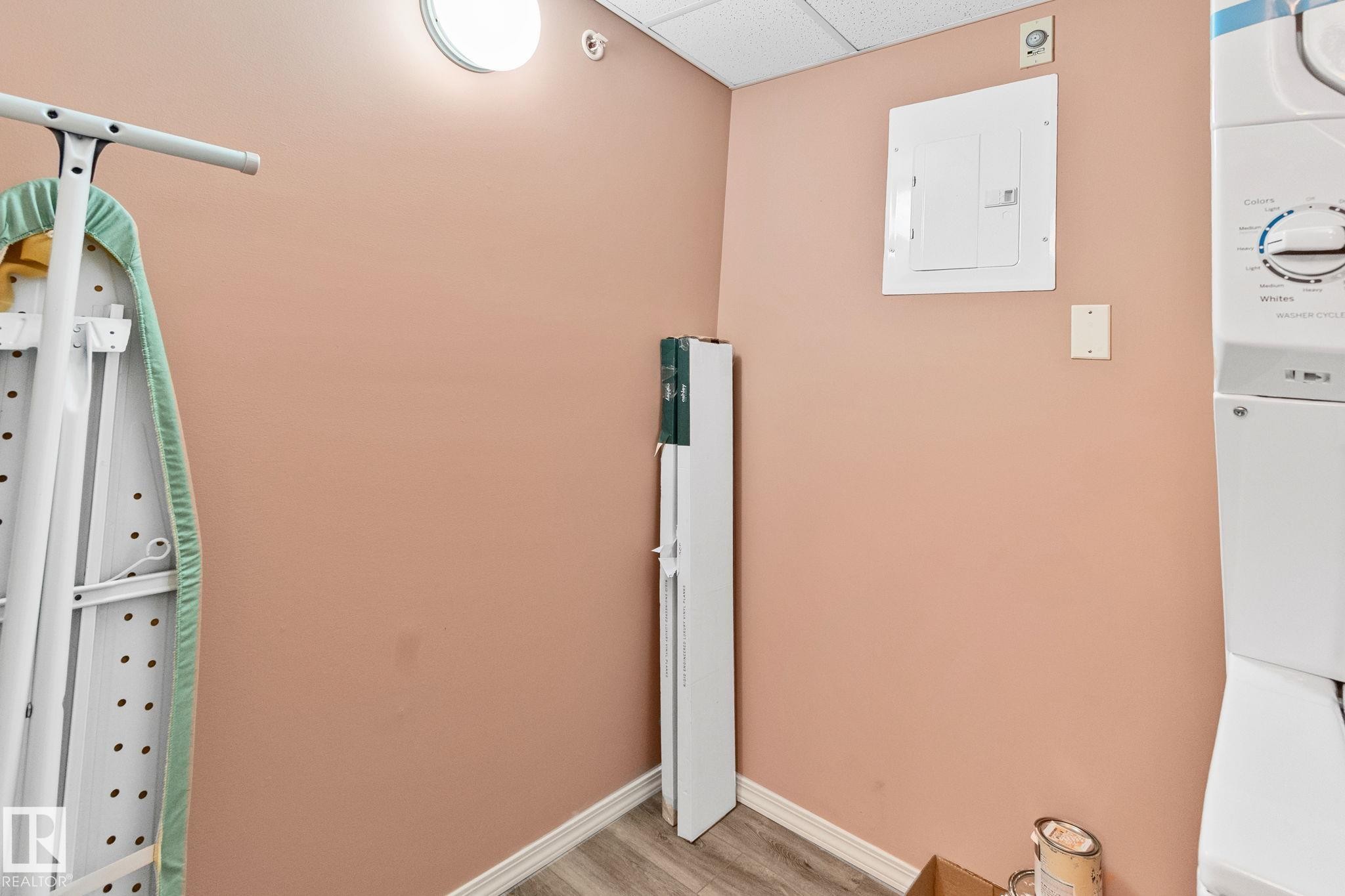 Detailed view of a paneled ceiling, electric panel, wood finished floors, and washer / clothes dryer - 406 16035 132 Street Nw, Edmonton, AB - Indoor