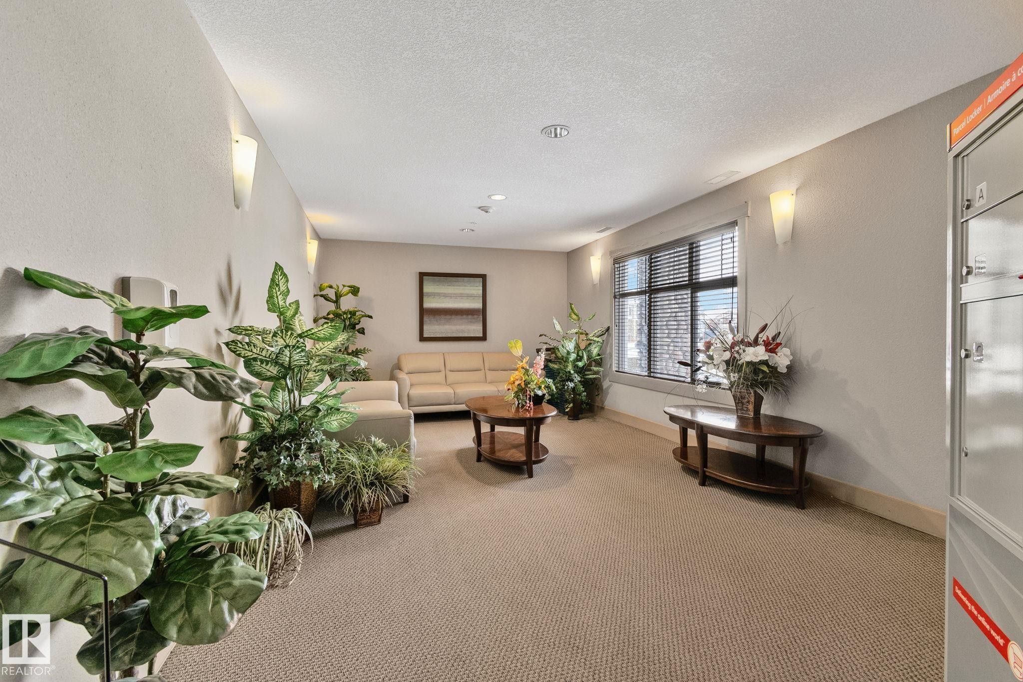 Carpeted living room featuring a textured ceiling - 406 16035 132 Street Nw, Edmonton, AB - Indoor
