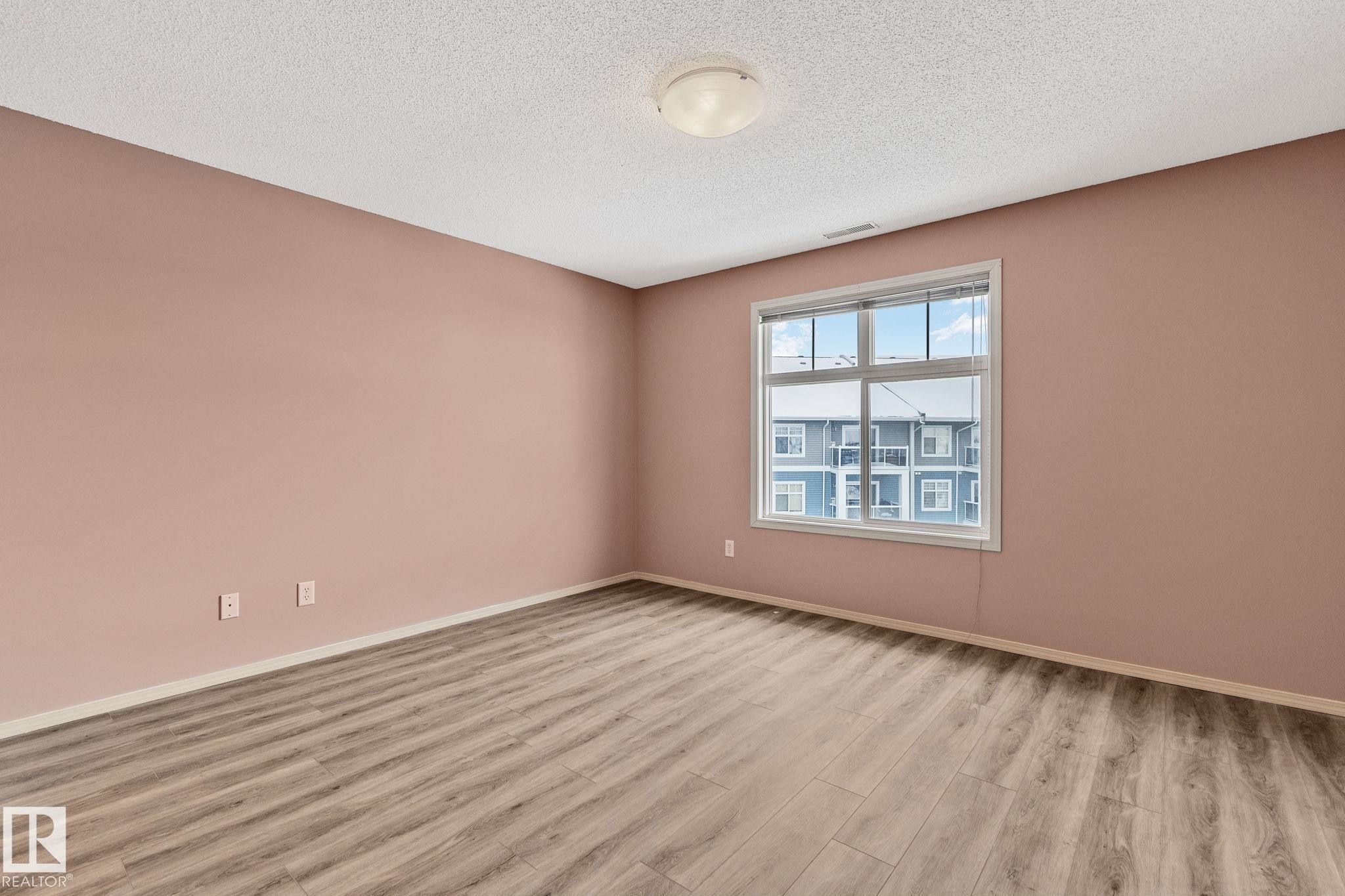 Unfurnished room featuring light wood-style flooring and a textured ceiling - 406 16035 132 Street Nw, Edmonton, AB - Indoor Photo Showing Other Room
