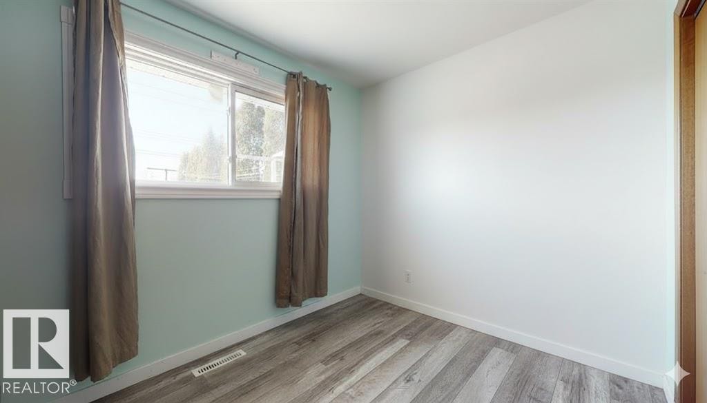 Empty room with light wood-type flooring and baseboards - 4706 53 St, Leduc, AB - Indoor Photo Showing Other Room