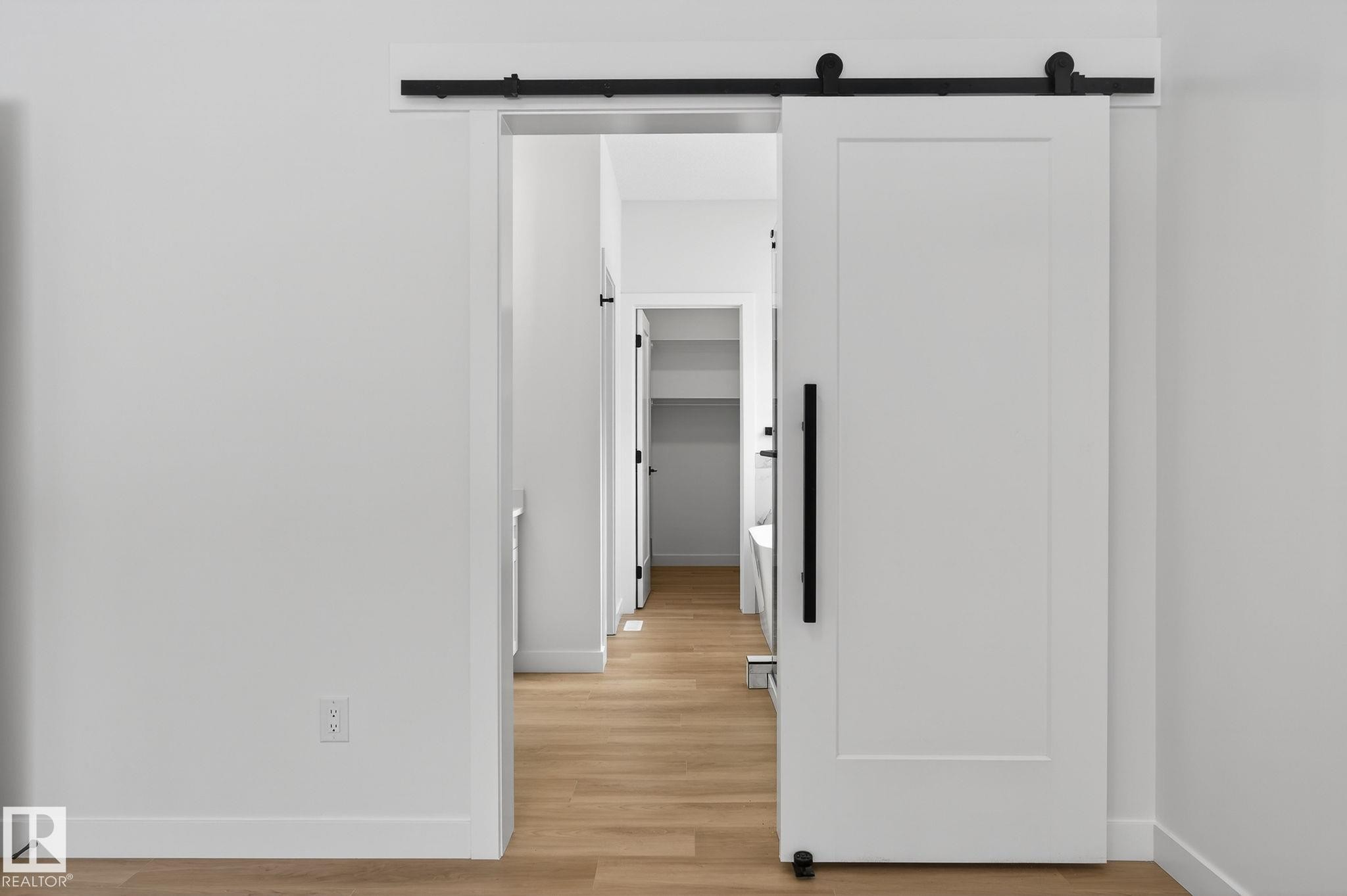 Hall featuring a barn door and light wood-type flooring - 3318 Chickadee Drive, Edmonton, AB - Indoor Photo Showing Other Room