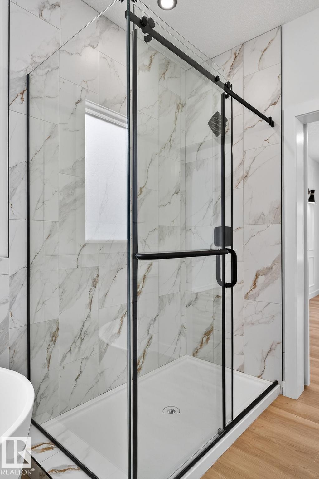 Full bathroom featuring a marble finish shower, a freestanding tub, and light wood-style flooring - 3318 Chickadee Drive, Edmonton, AB - Indoor Photo Showing Bathroom