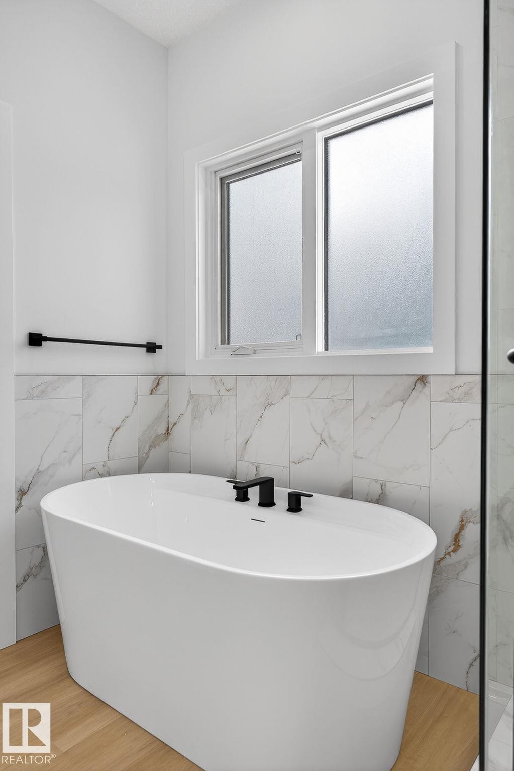 Bathroom with a freestanding tub, tile walls, and wainscoting - 3318 Chickadee Drive, Edmonton, AB - Indoor Photo Showing Bathroom