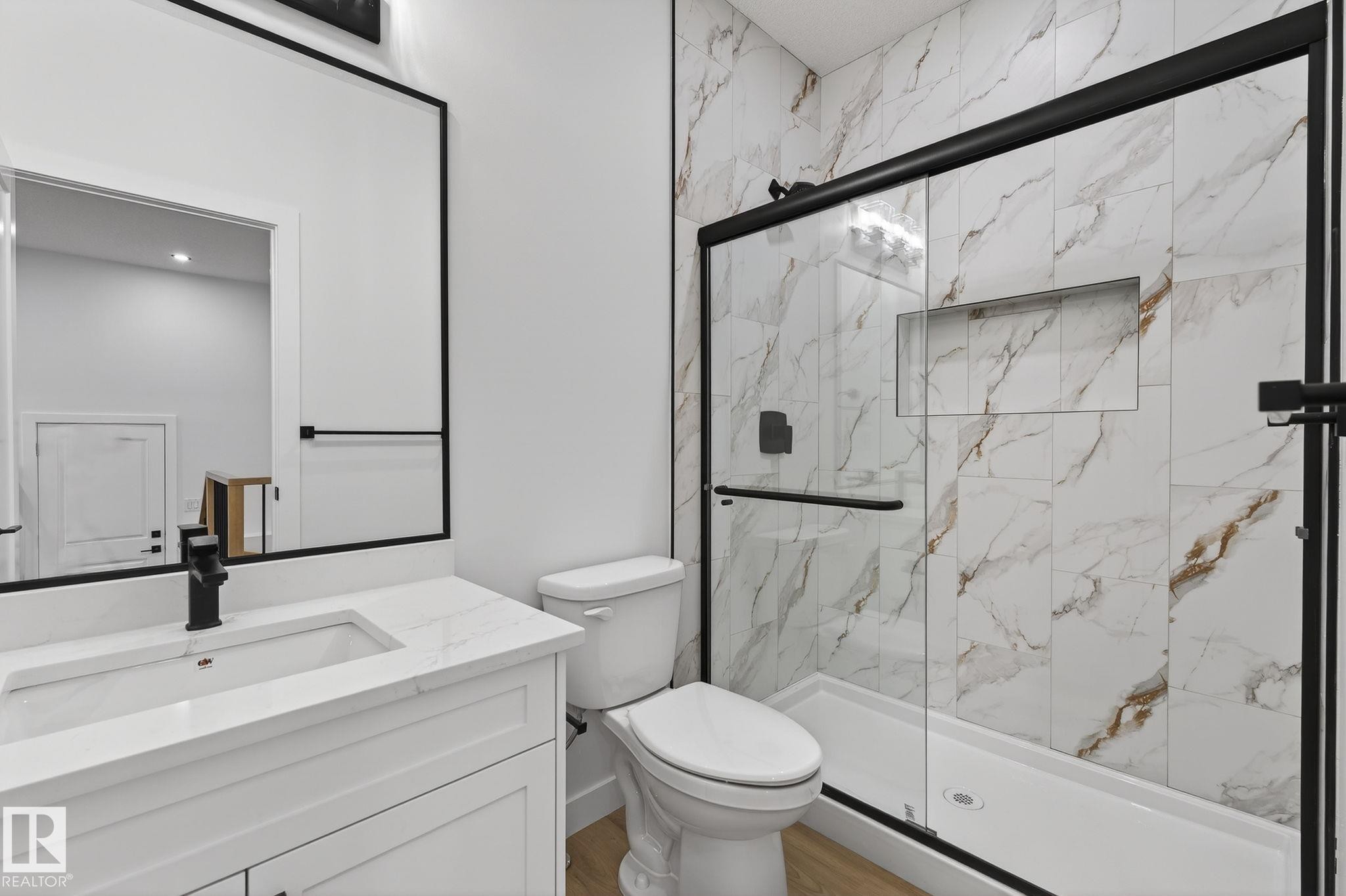Full bathroom featuring vanity, a marble finish shower, and wood finished floors - 3318 Chickadee Drive, Edmonton, AB - Indoor Photo Showing Bathroom