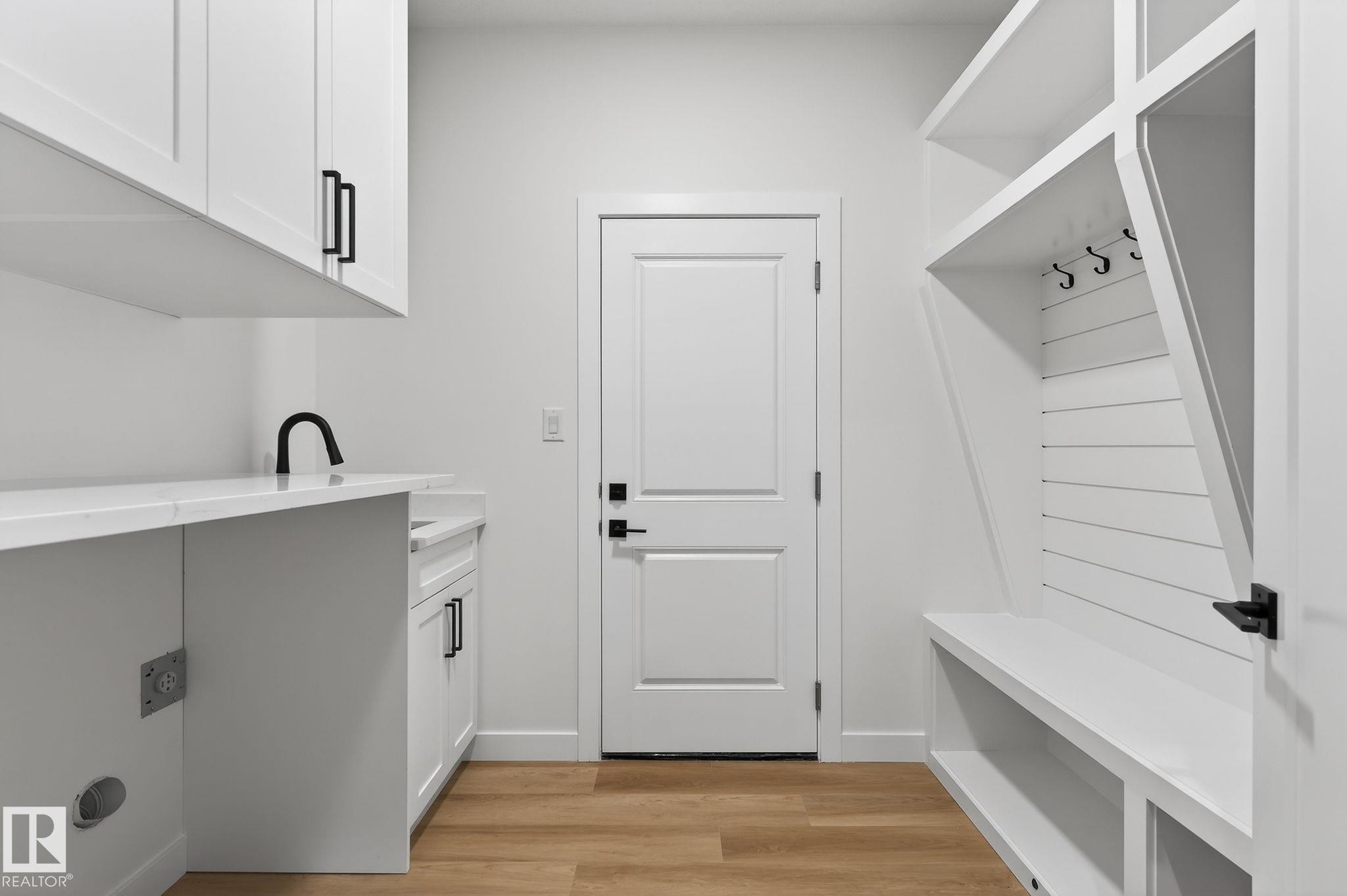 Laundry room featuring light wood-type flooring and cabinet space - 3318 Chickadee Drive, Edmonton, AB - Indoor