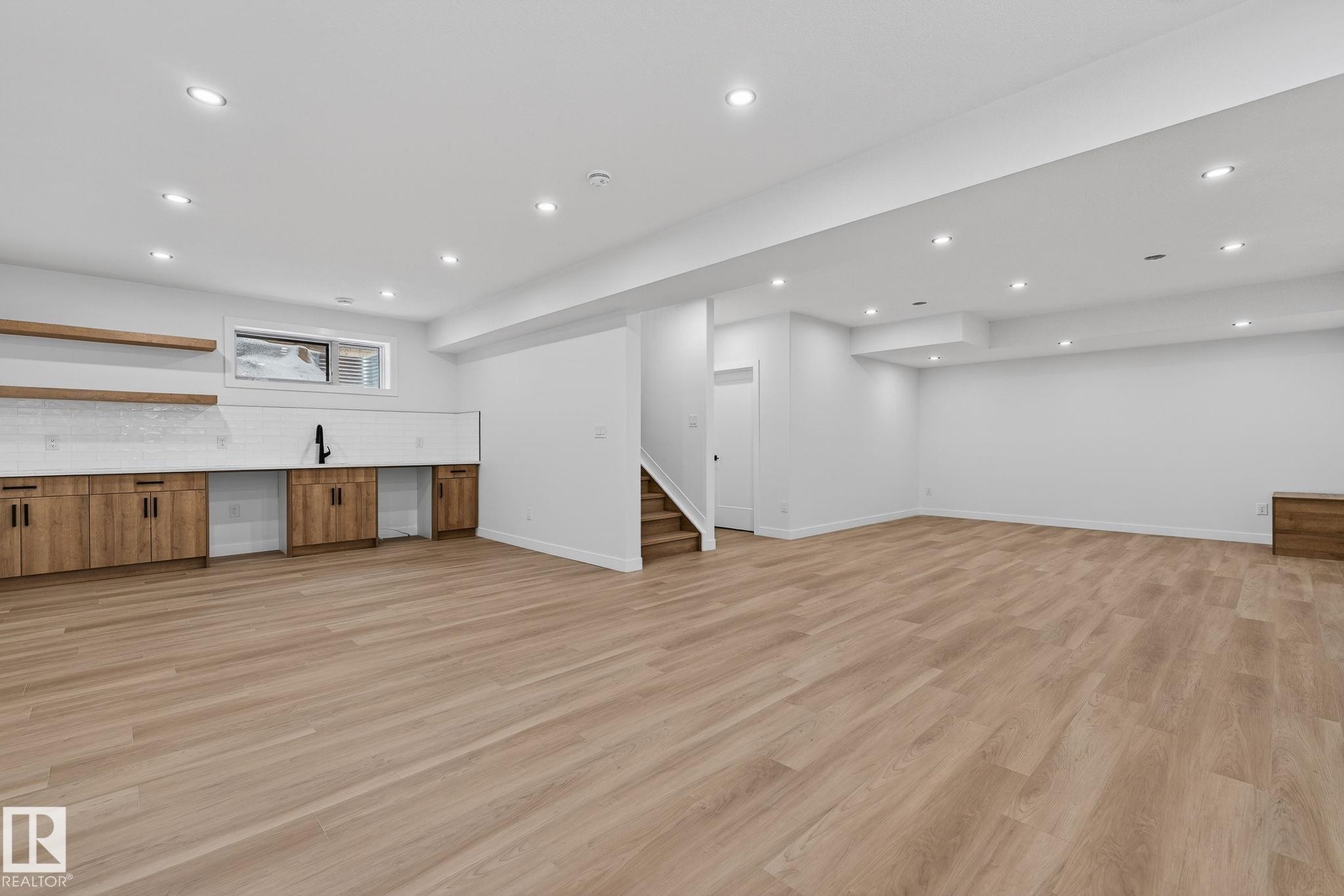 Basement featuring light wood-style floors, recessed lighting, wet bar, and stainless steel fridge - 3318 Chickadee Drive, Edmonton, AB - Indoor