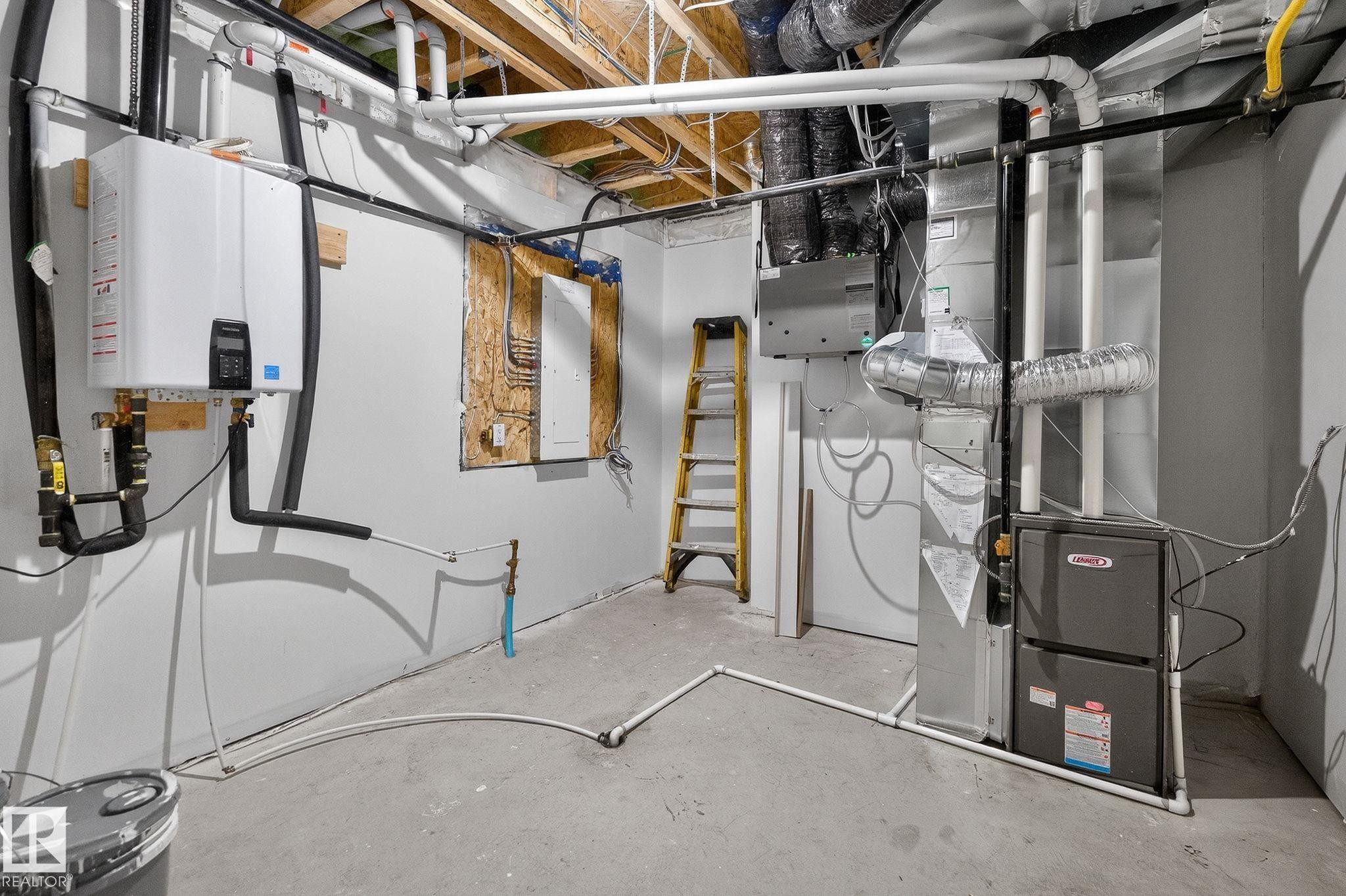 Utility room featuring heating unit, electric panel, and tankless water heater - 3318 Chickadee Drive, Edmonton, AB - Indoor Photo Showing Basement
