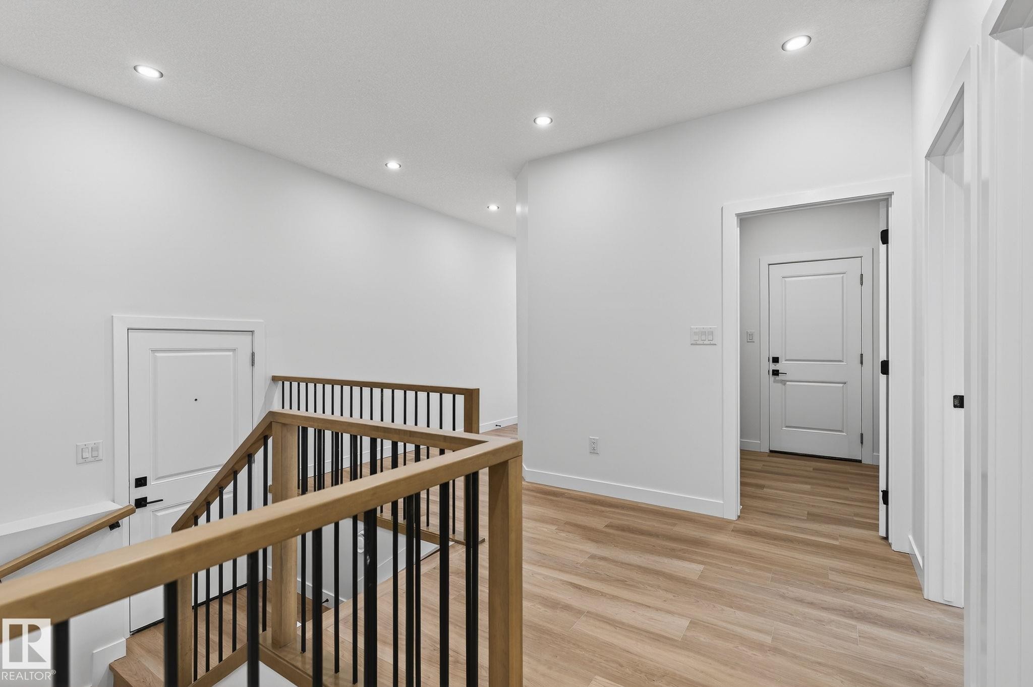 Hallway with an upstairs landing, light wood-style flooring, and recessed lighting - 3318 Chickadee Drive, Edmonton, AB - Indoor Photo Showing Other Room