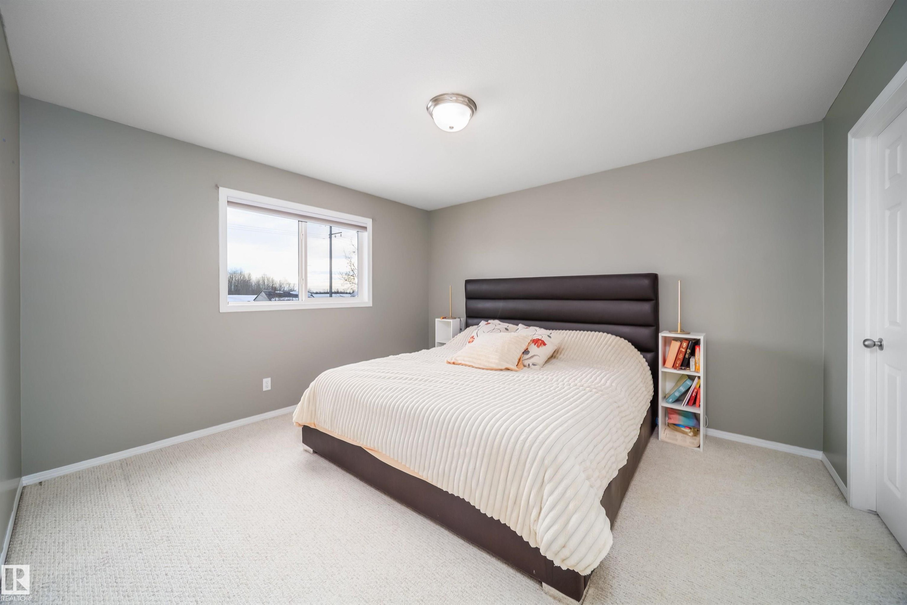 Bedroom featuring light colored carpet and baseboards - 1179 Oakland Drive, Devon, AB - Indoor Photo Showing Bedroom