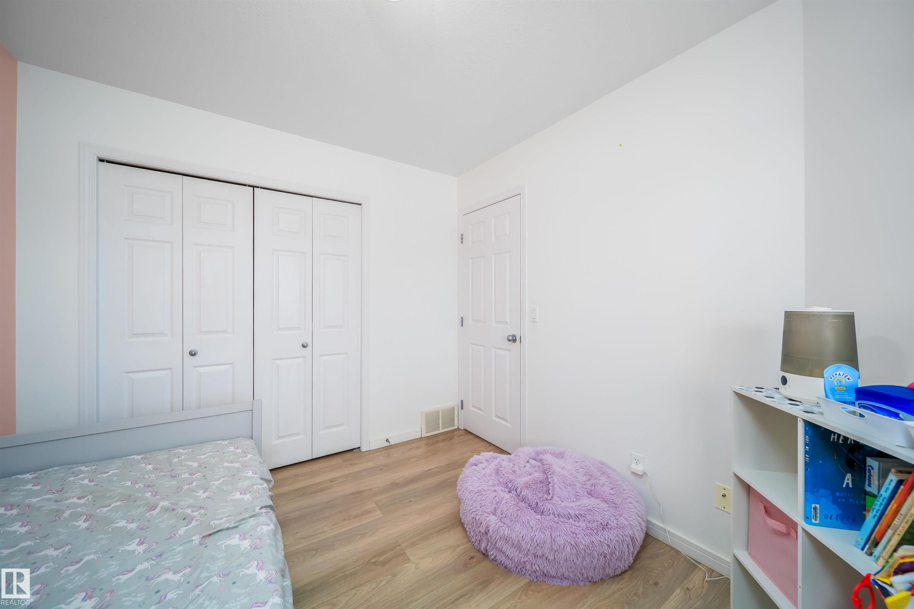 Bedroom featuring light wood finished floors and a closet - 1179 Oakland Drive, Devon, AB - Indoor Photo Showing Bedroom