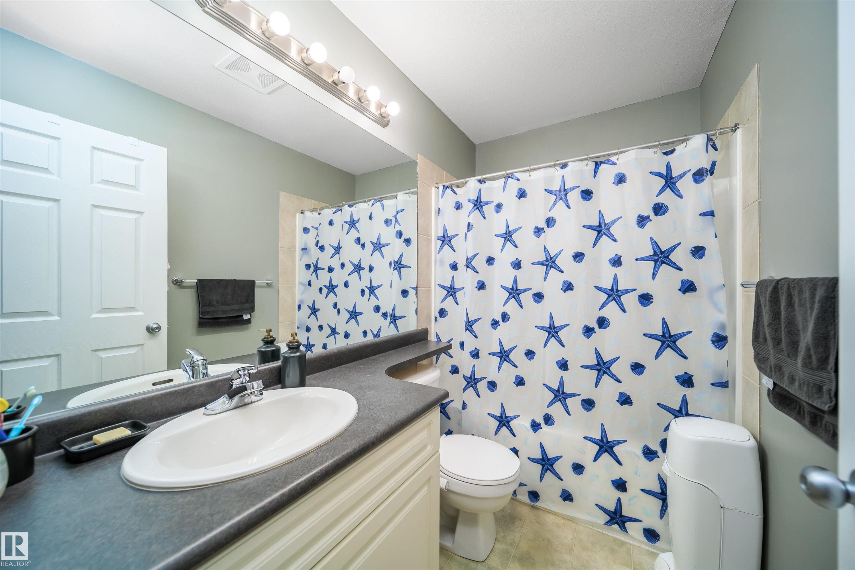 Bathroom with vanity and shower / tub combo with curtain - 1179 Oakland Drive, Devon, AB - Indoor Photo Showing Bathroom