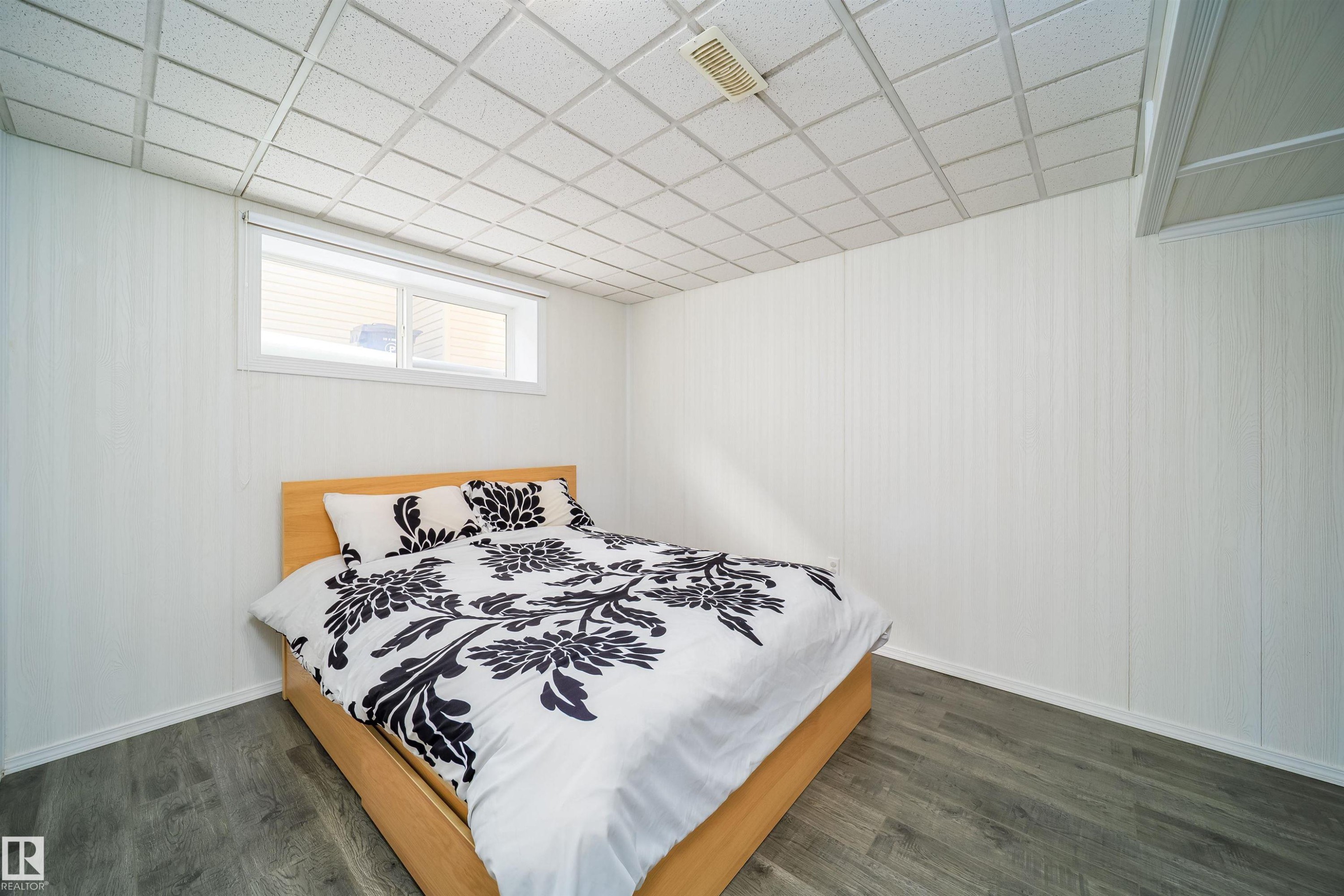 Bedroom featuring a paneled ceiling and dark wood finished floors - 1179 Oakland Drive, Devon, AB - Indoor Photo Showing Bedroom