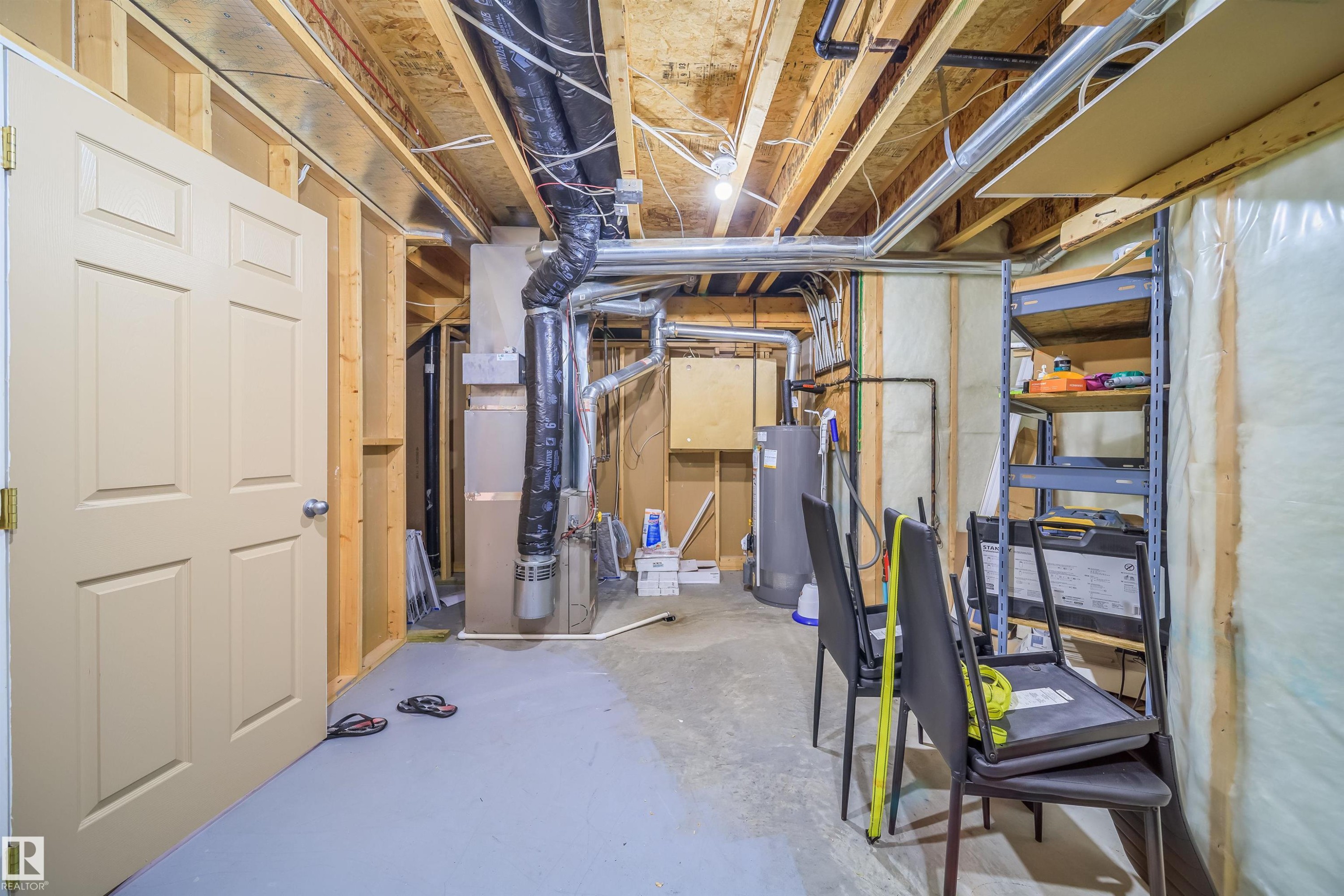 Unfinished basement with heating unit and water heater - 1179 Oakland Drive, Devon, AB - Indoor Photo Showing Basement