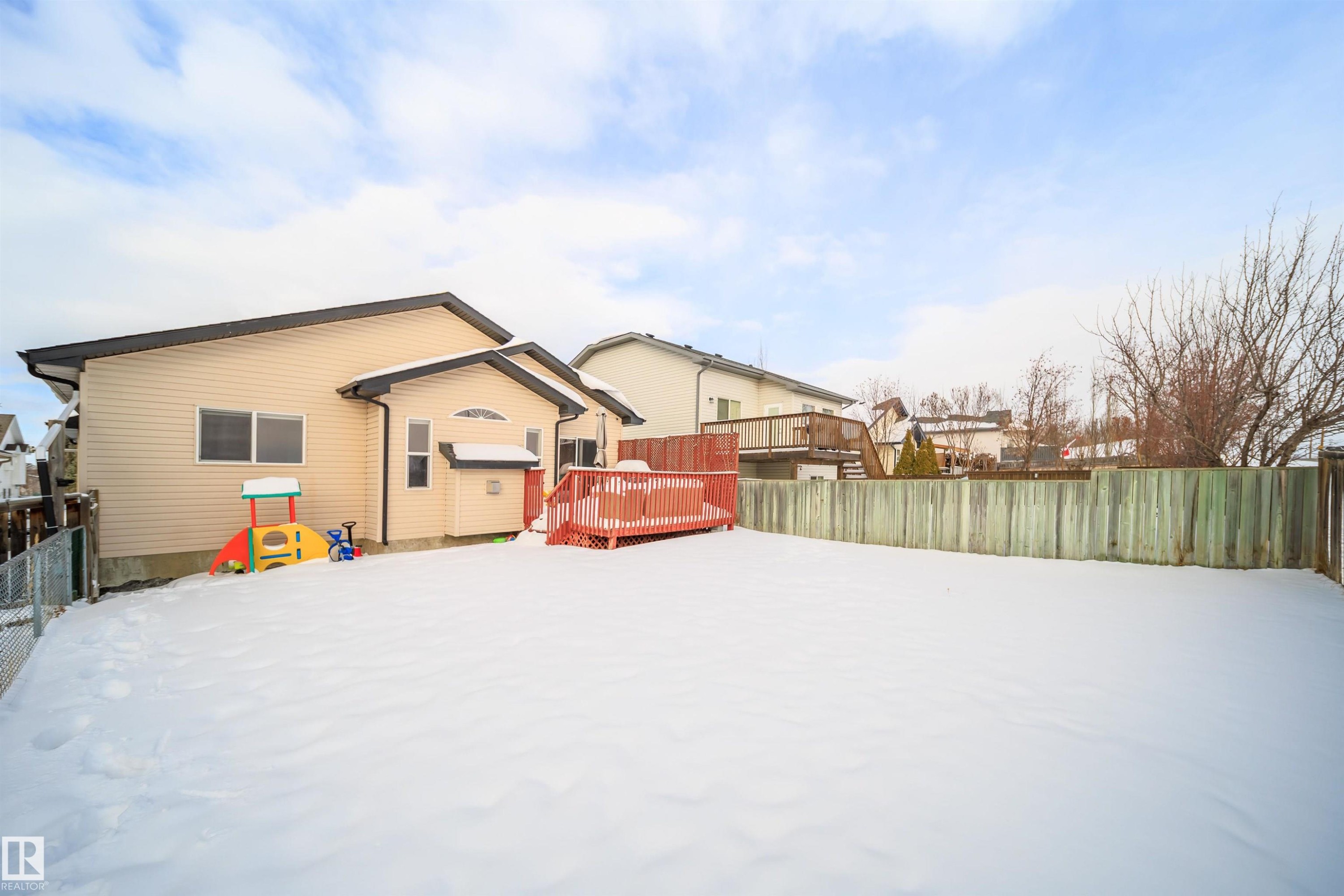 Snow covered rear of property with a deck - 1179 Oakland Drive, Devon, AB - Outdoor