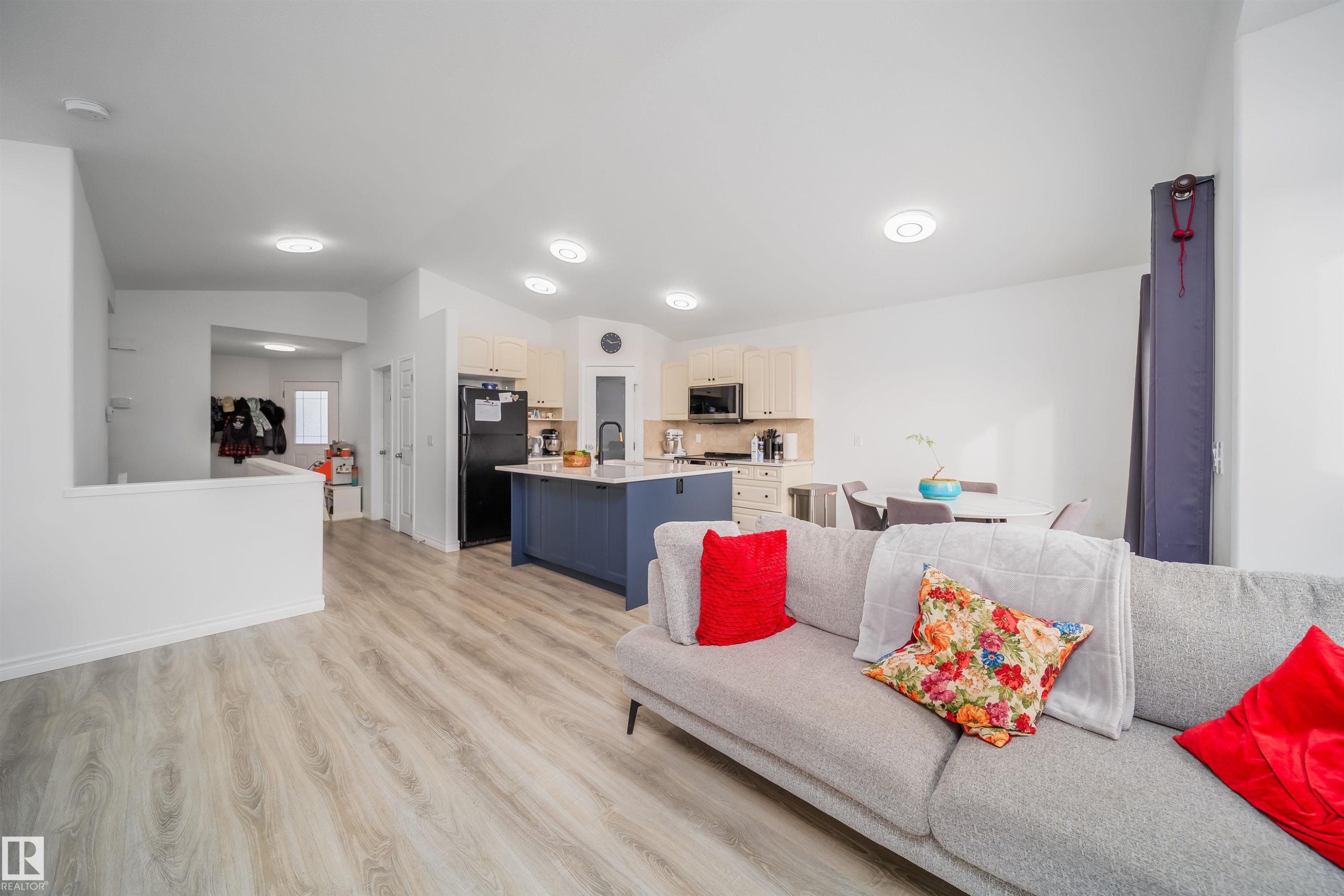 Living area with light wood-style floors and vaulted ceiling - 1179 Oakland Drive, Devon, AB - Indoor Photo Showing Living Room