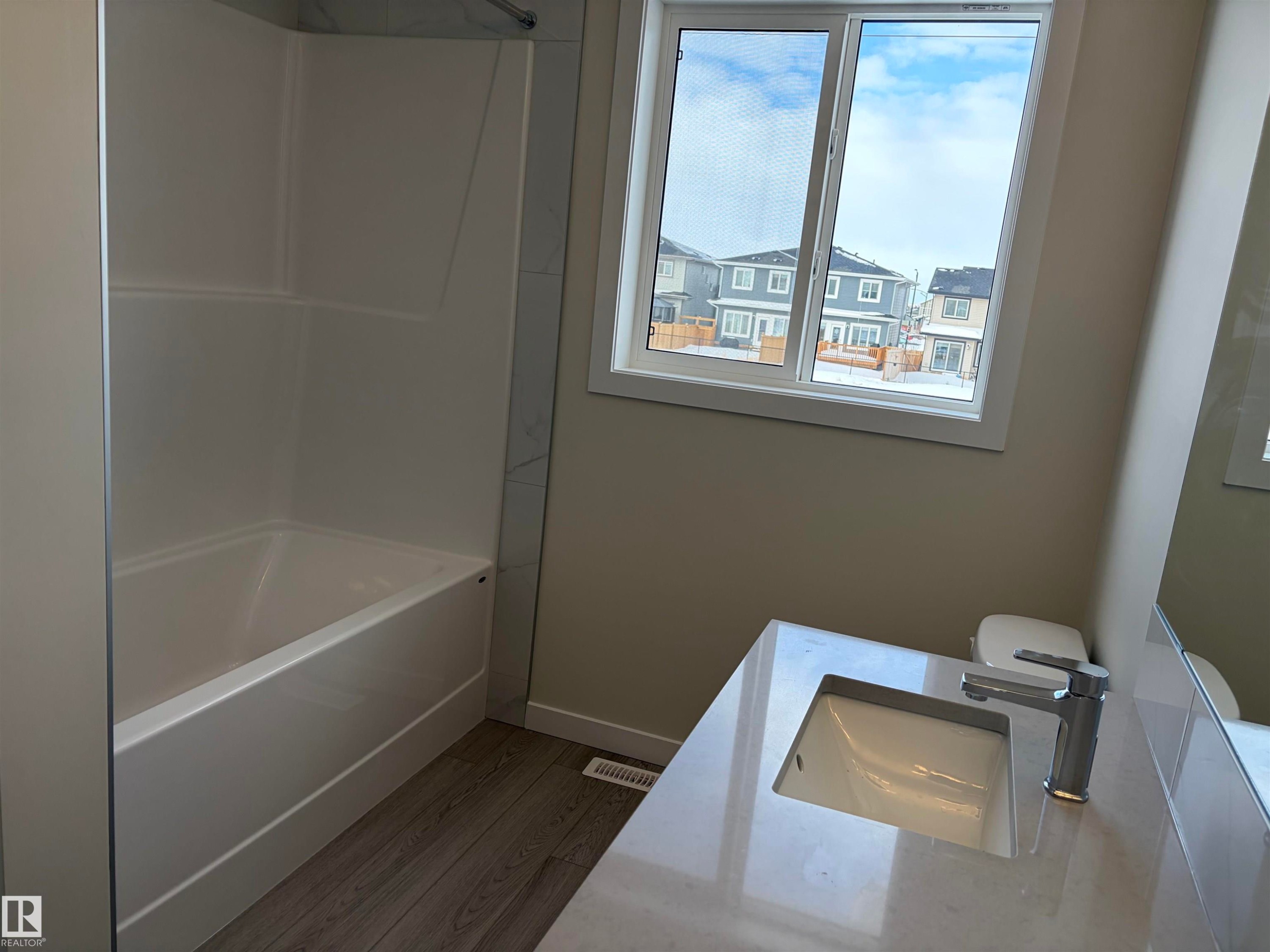 Bathroom with vanity, dark wood finished floors, and shower combination - 5756 Hawthorn Common, Edmonton, AB - Indoor Photo Showing Bathroom